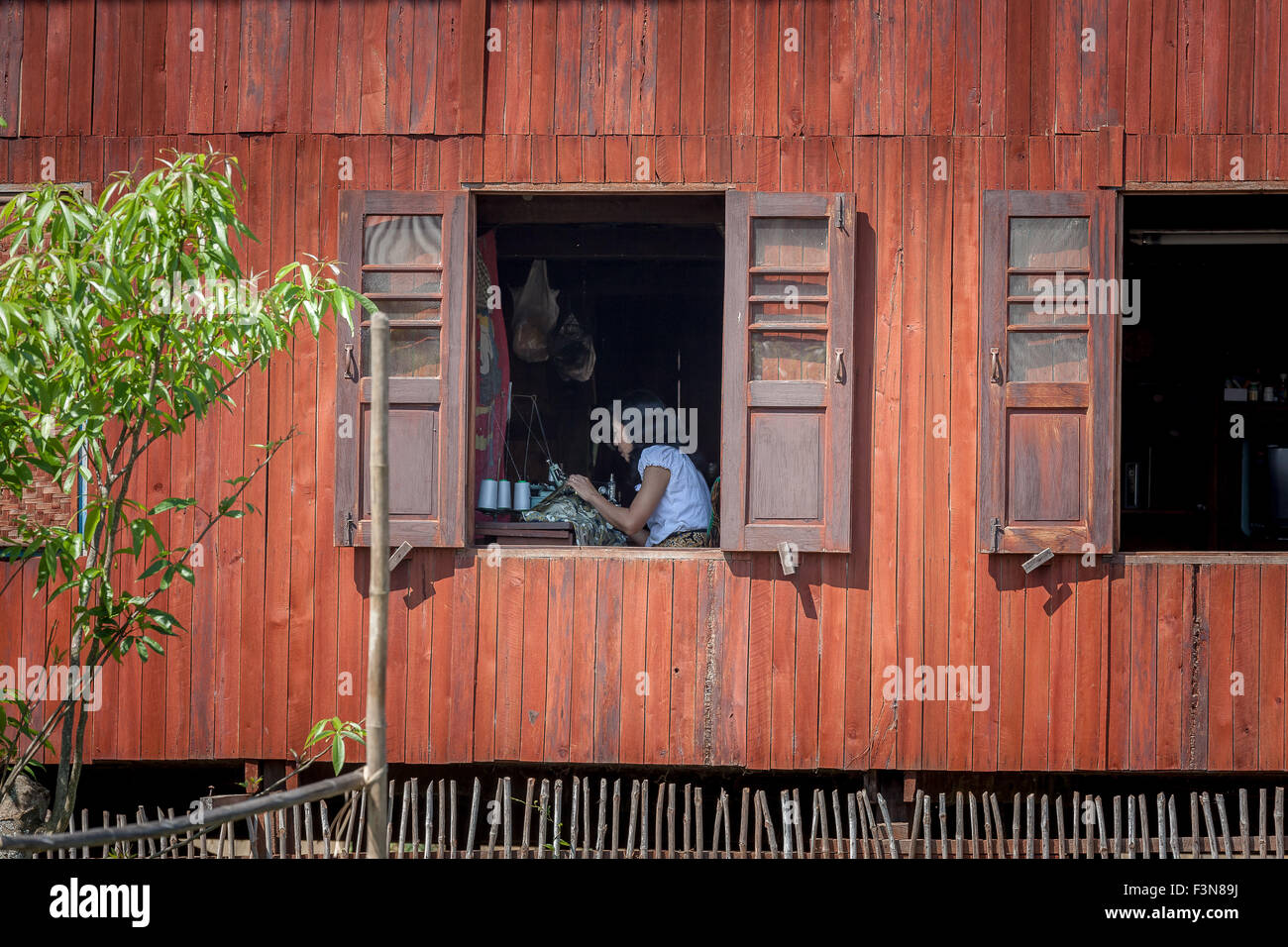 Couture femme par la fenêtre. Nampan (Nam Pan) Village. Banque D'Images