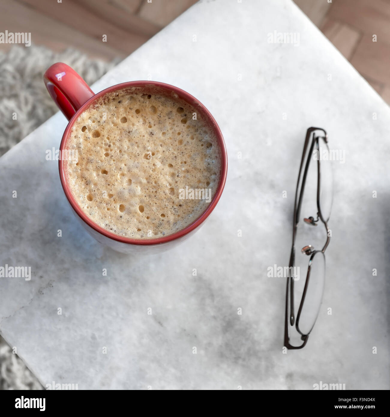 Tasse de café en rouge sur une table en marbre, d'en haut Banque D'Images