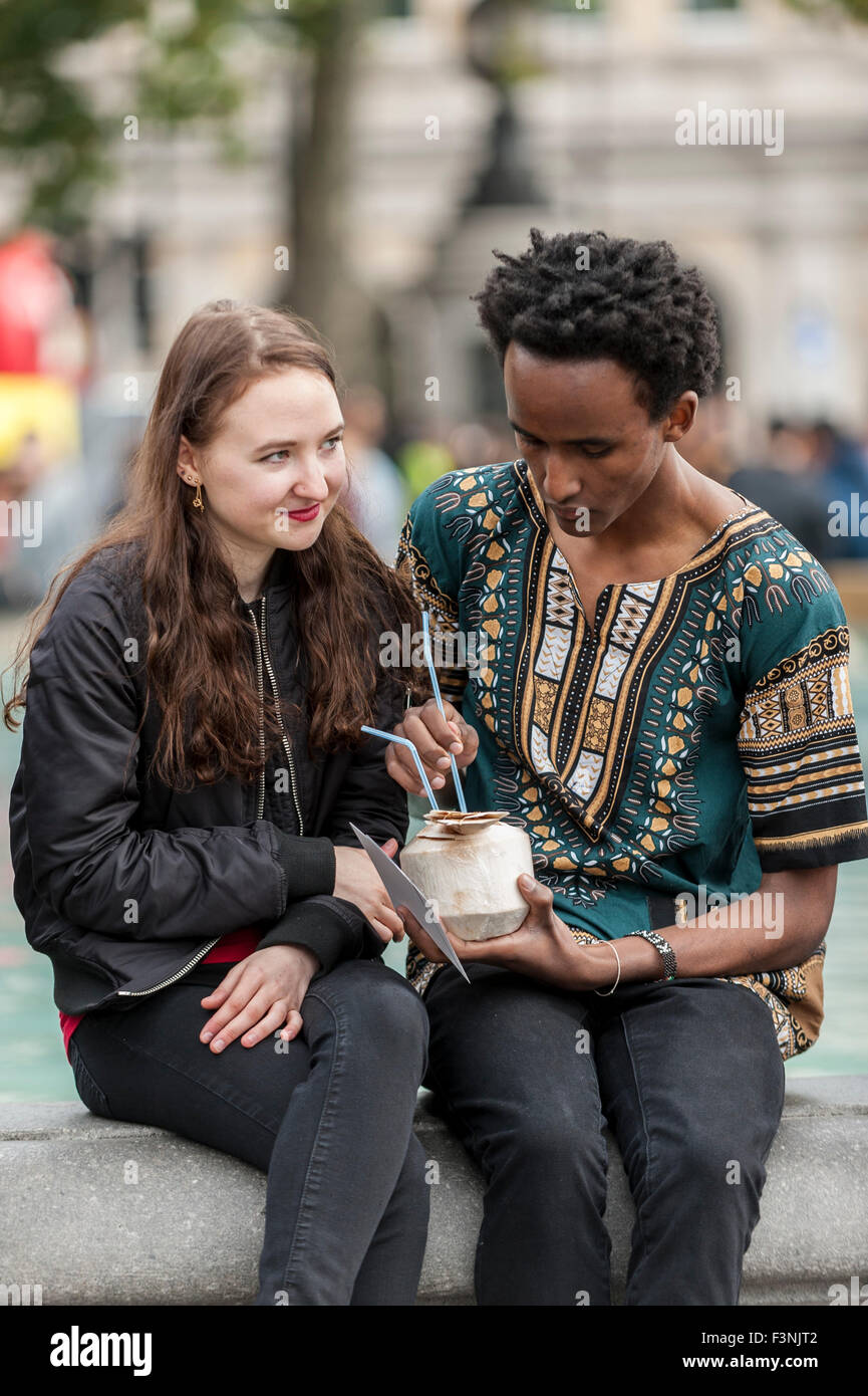 Londres, Royaume-Uni. 10 octobre 2015. Un couple de partager un verre à partir d'une noix de coco fraîche comme des milliers de personnes se rassemblent à Trafalgar Square pour "l'Afrique sur la Place', un festival de la culture africaine. L'événement est organisé par le maire de Londres pour le mois de l'histoire des Noirs 2015. Crédit : Stephen Chung / Alamy Live News Banque D'Images