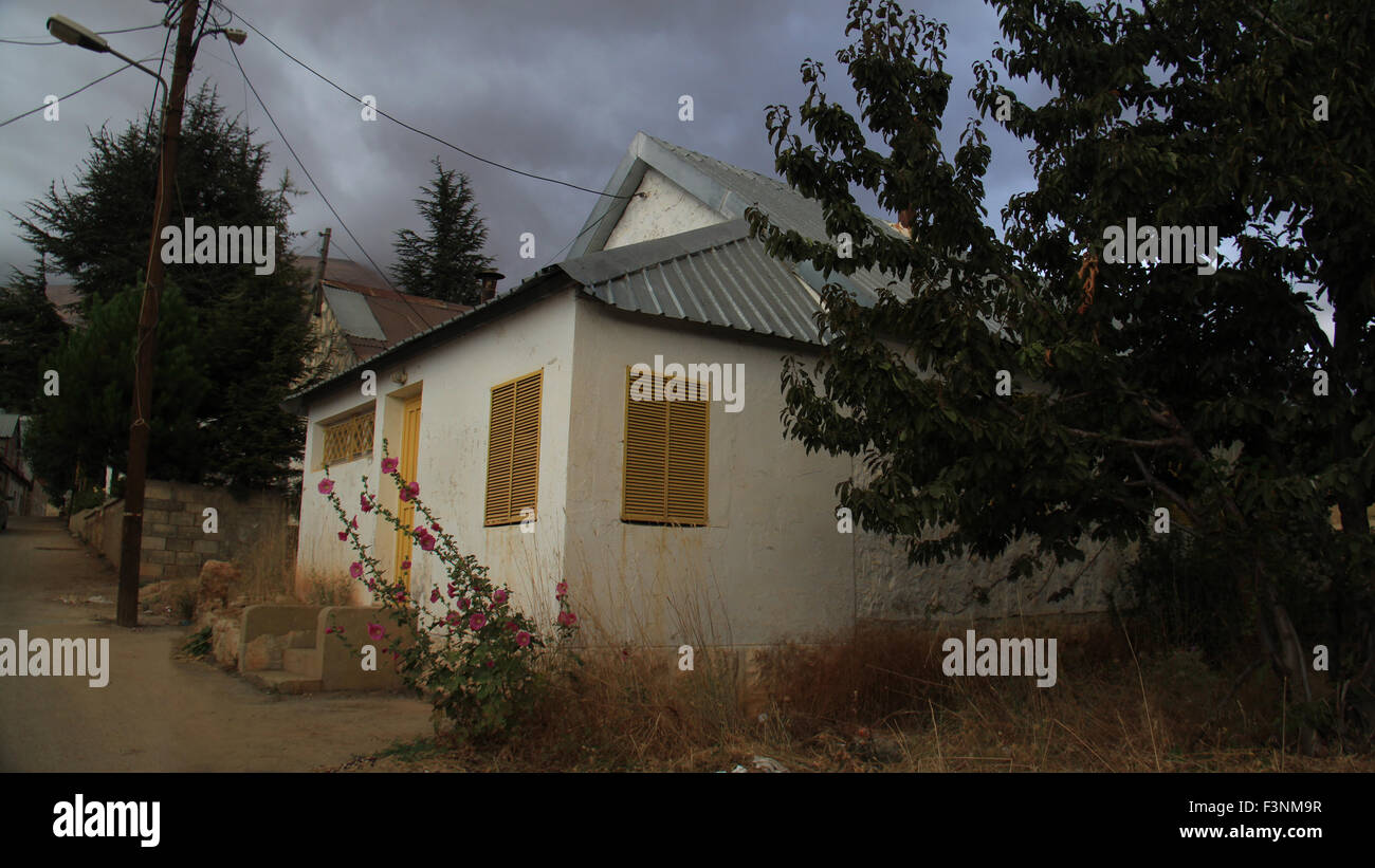 Une maison jaune avec lunatique windows sur une sombre soirée d'automne. Banque D'Images