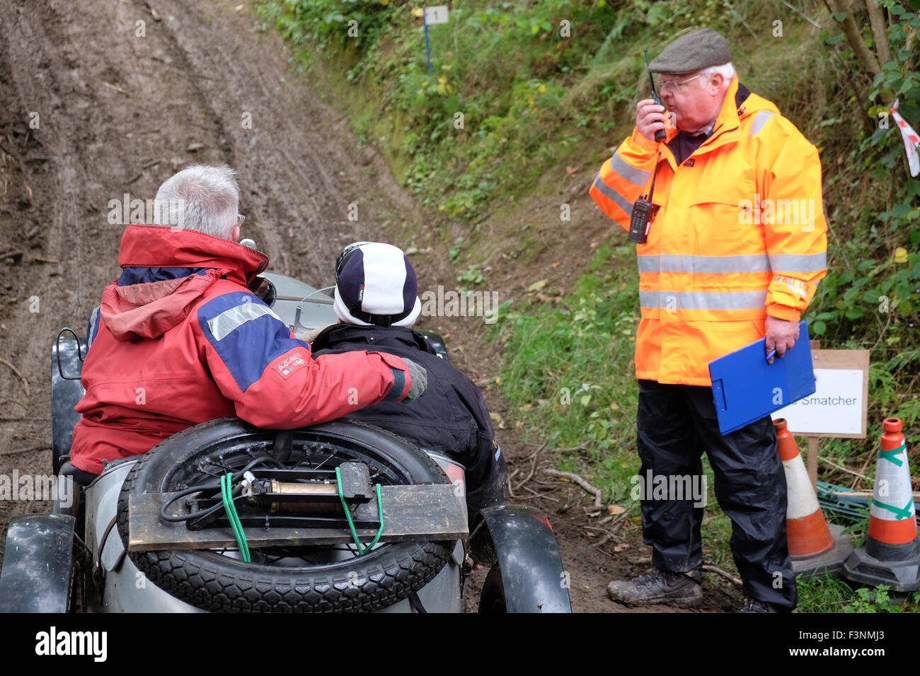 New Radnor, Powys, Wales - Samedi 10 Octobre 2015 - Le Vintage Sports Car Club ( CSECC ) Hill Climb sur le défi d'un Smatcher pentes boisées colline, tout près de New Radnor. L'office de 'bouncer' qui rebondit pour aider la voiture prise sur les sections escarpées. Un concurrent dans une Austin Seven attend que le commissaire de pistes de signal qu'ils peuvent commencer leur course jusqu'à la colline. Banque D'Images