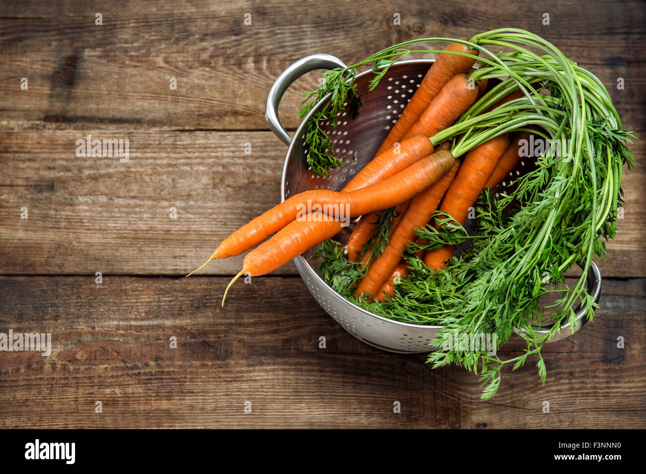 Les carottes avec feuilles vertes sur fond de bois rustique. Légume. L'alimentation. Tons style vintage photo Banque D'Images