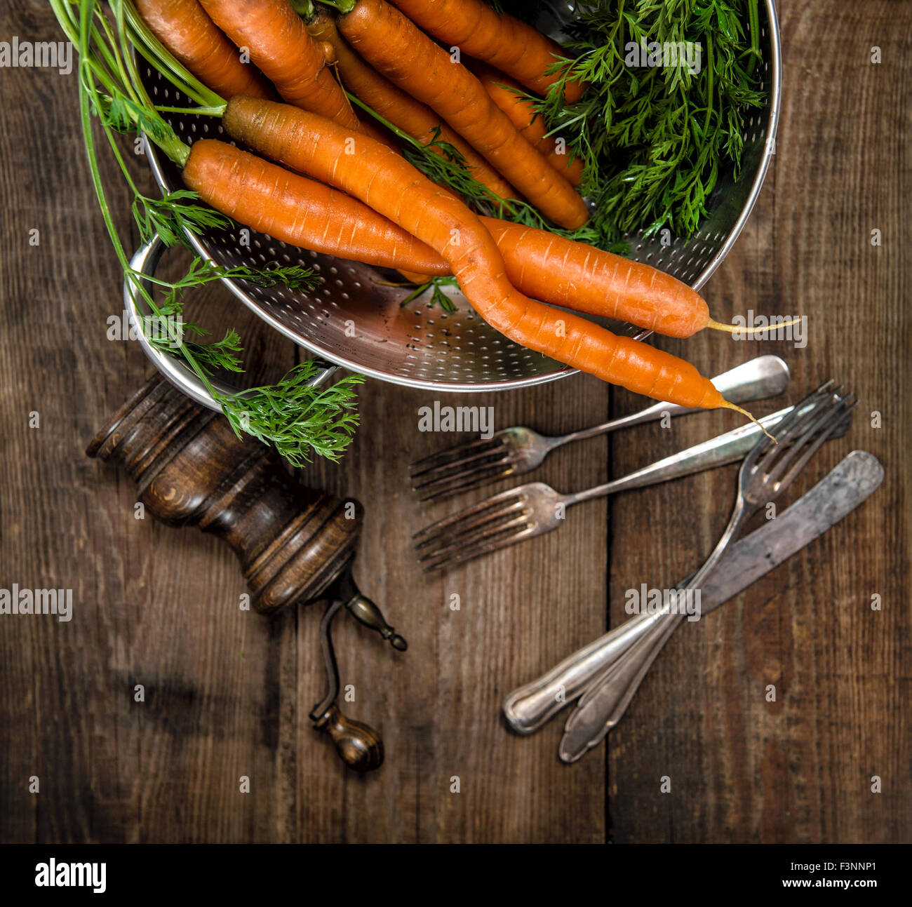 Les carottes avec feuilles vertes sur fond de bois rustique. Alimentation saine. Légumes Banque D'Images