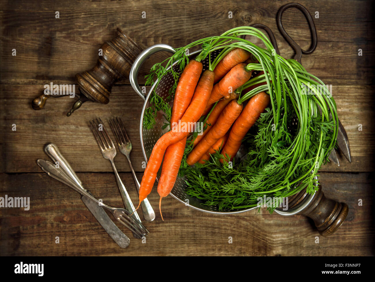 Les carottes avec feuilles vertes sur fond de bois rustique. Légume. Concept alimentaire du pays. Tons style vintage photo Banque D'Images