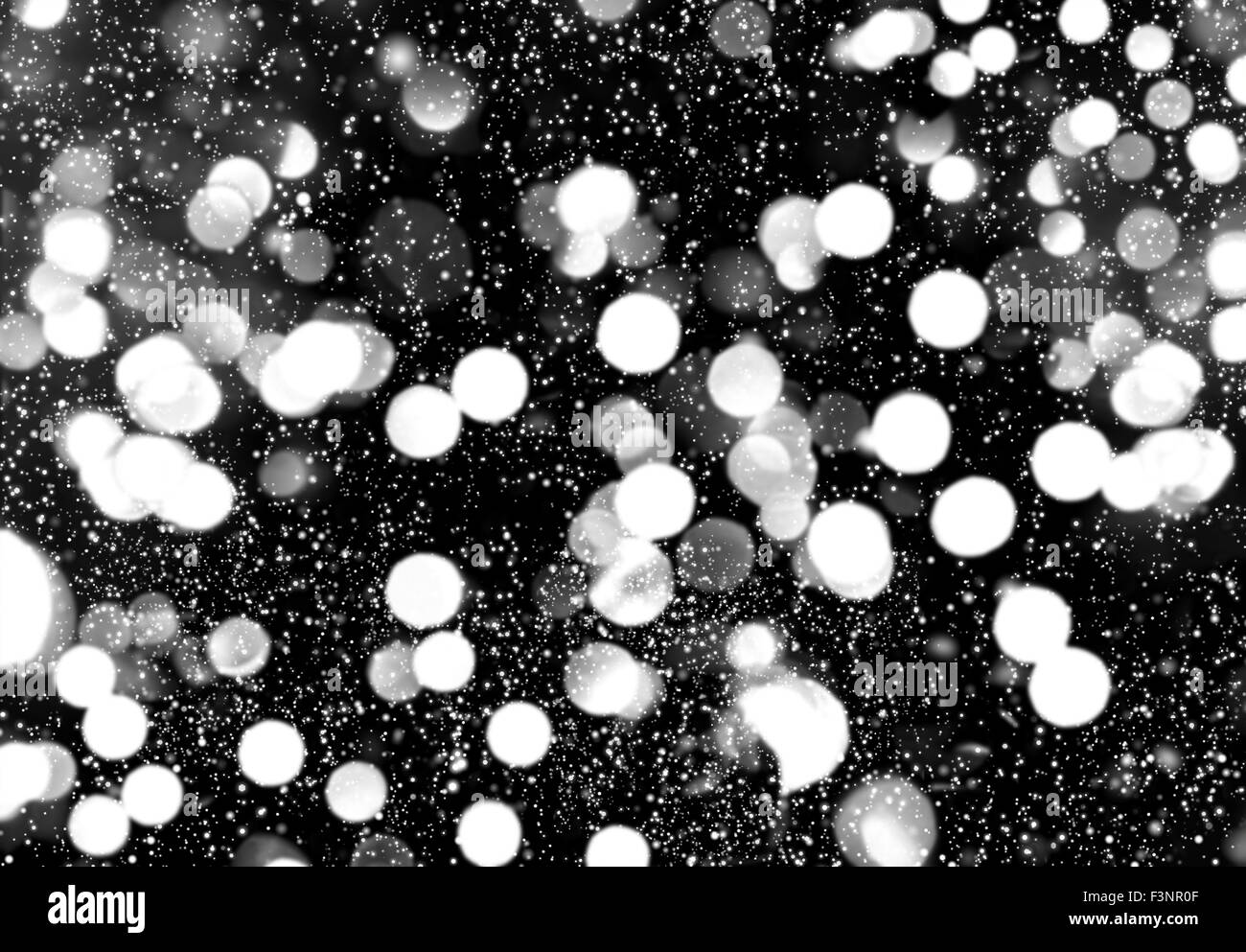 Feux de flou artistique avec effet de neige. Nuit d'hiver à la ville. Abstract black white background Banque D'Images