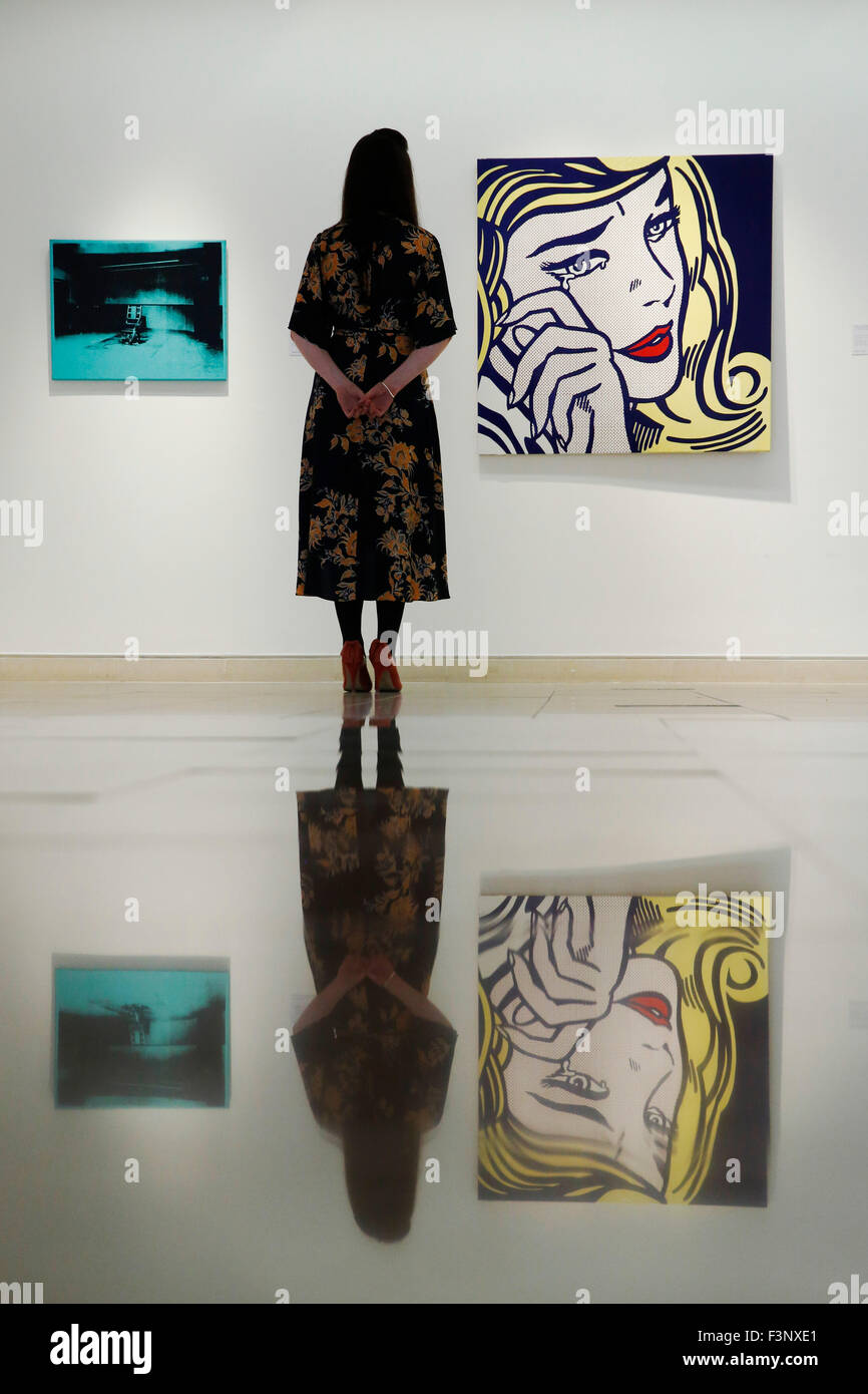 Un employé de Christie's pose avec les œuvres de l'artiste Roy Lichtenstein ' Crying Girl' (R) et Andy Warhol's 'Petite chaise électrique' Maison de vente aux enchères chez Christie's à Londres, Royaume-Uni Le vendredi 9 octobre 2015. Ils sont tous deux attendus à US $9million de dollars lorsqu'ils viennent de mettre aux enchères à New York en novembre. Ils seront sur l'affichage au Royaume-Uni durant Frieze Art Fair semaine jusqu'au 17 octobre. Banque D'Images