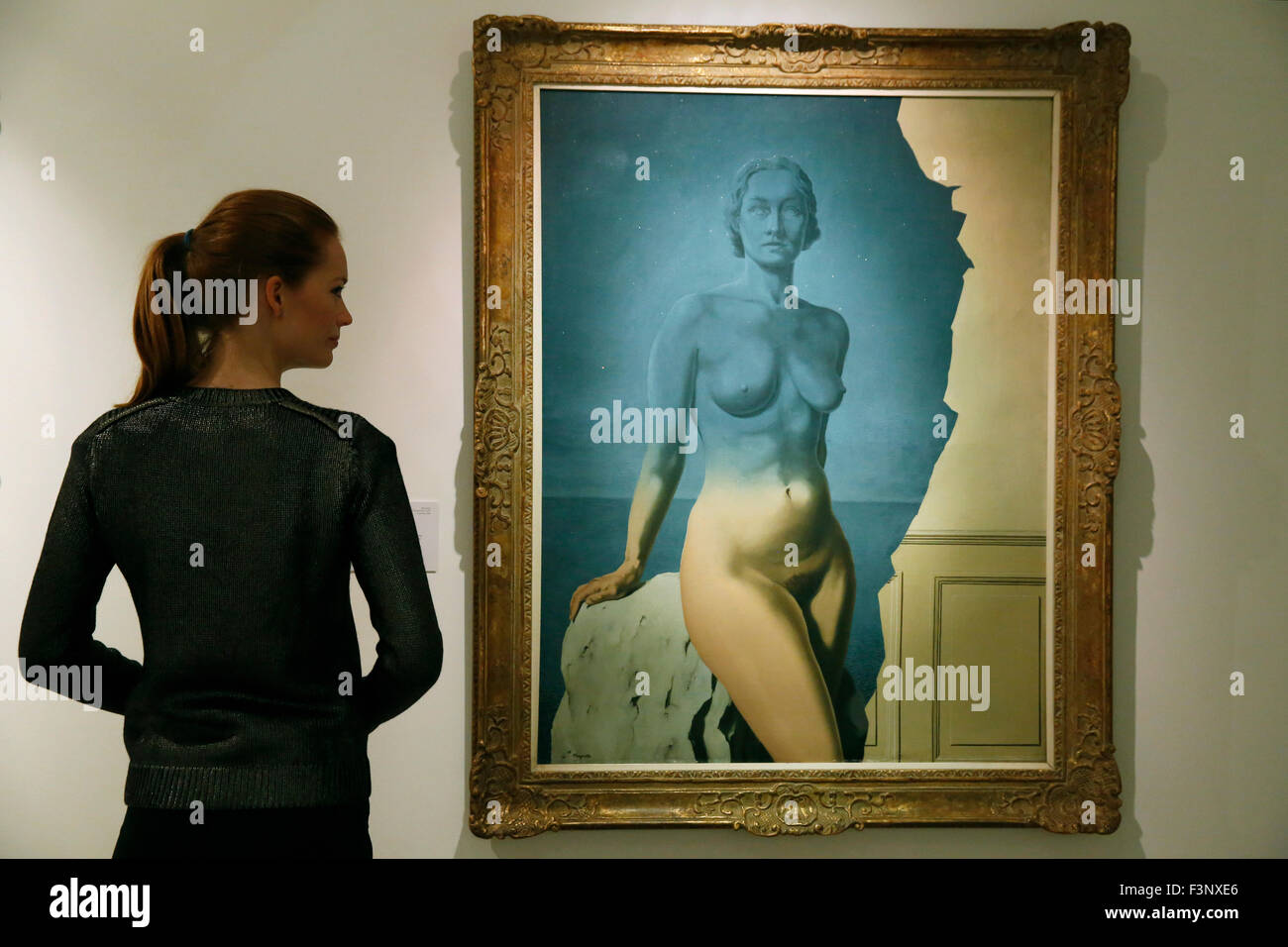 Un employé de Christie's pose avec l'artiste René Magritte's 'Le Mirroir Univers !' en maison de ventes aux enchères Christie's à Londres, Royaume-Uni, le vendredi 9 octobre 2013. Il est prévu d'atteindre US $5 millions de dollars aux enchères à New York en novembre. Il sera sur affichez au Royaume-Uni durant Frieze Art Fair semaine jusqu'au 17 octobre. Banque D'Images