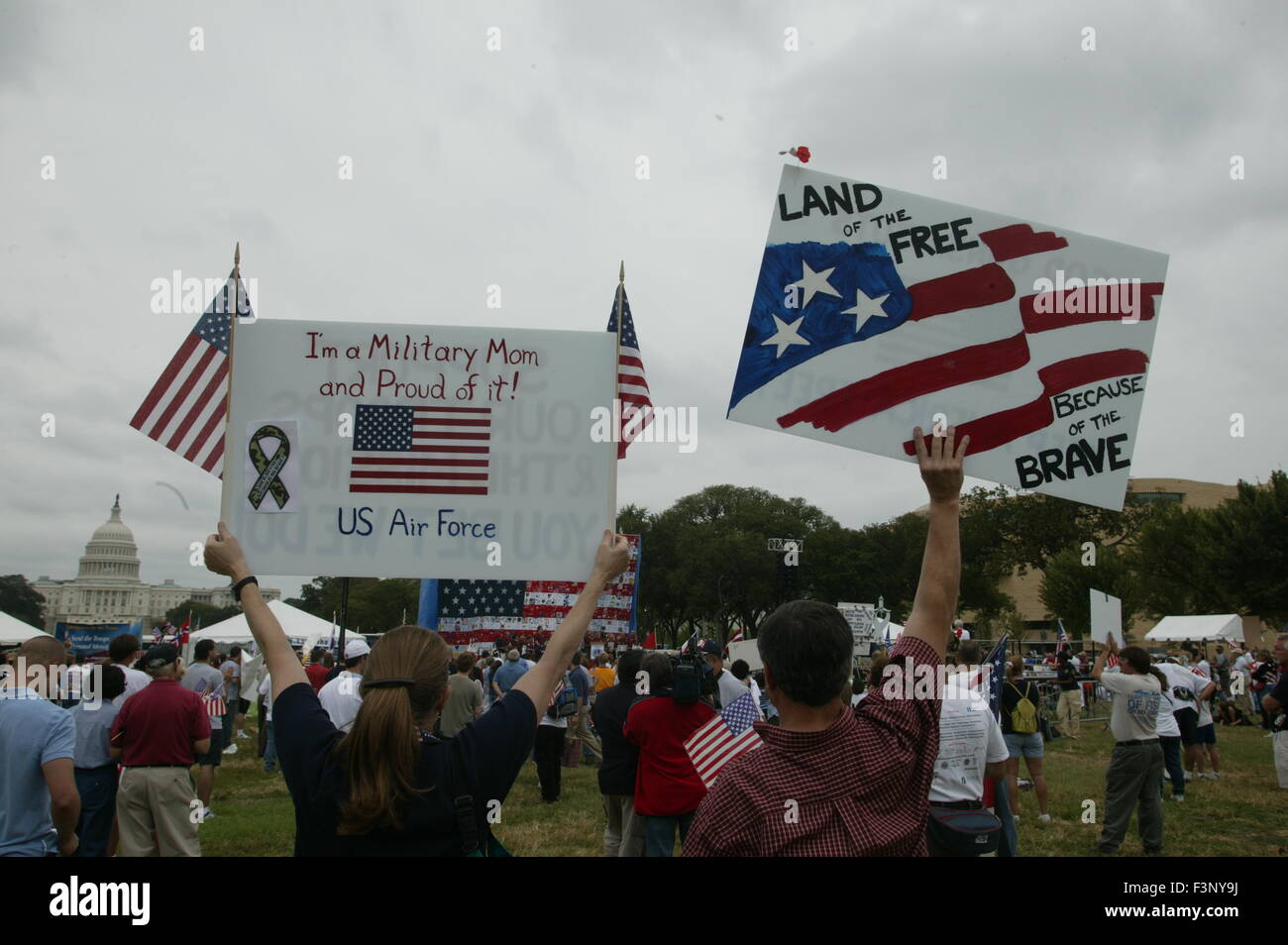 Les familles de militaires tenir signe avec le drapeau américain et des mains à un soutien des familles des militaires partisans tenir un rassemblement sur le National Mall à Washington D.C. Signer dit : 'Je suis une maman, militaire et fière de l'être." et "Pays de la liberté, Home of the Brave". Banque D'Images
