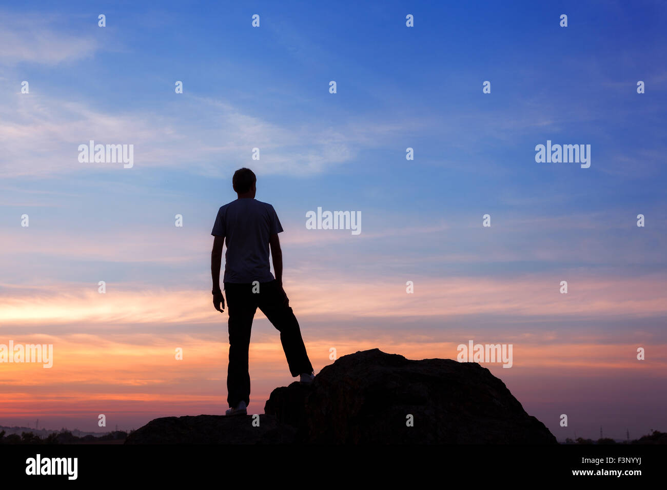 Silhouette d'un homme avec des bras à la magnifique coucher de soleil sur la montagne. Contexte Banque D'Images