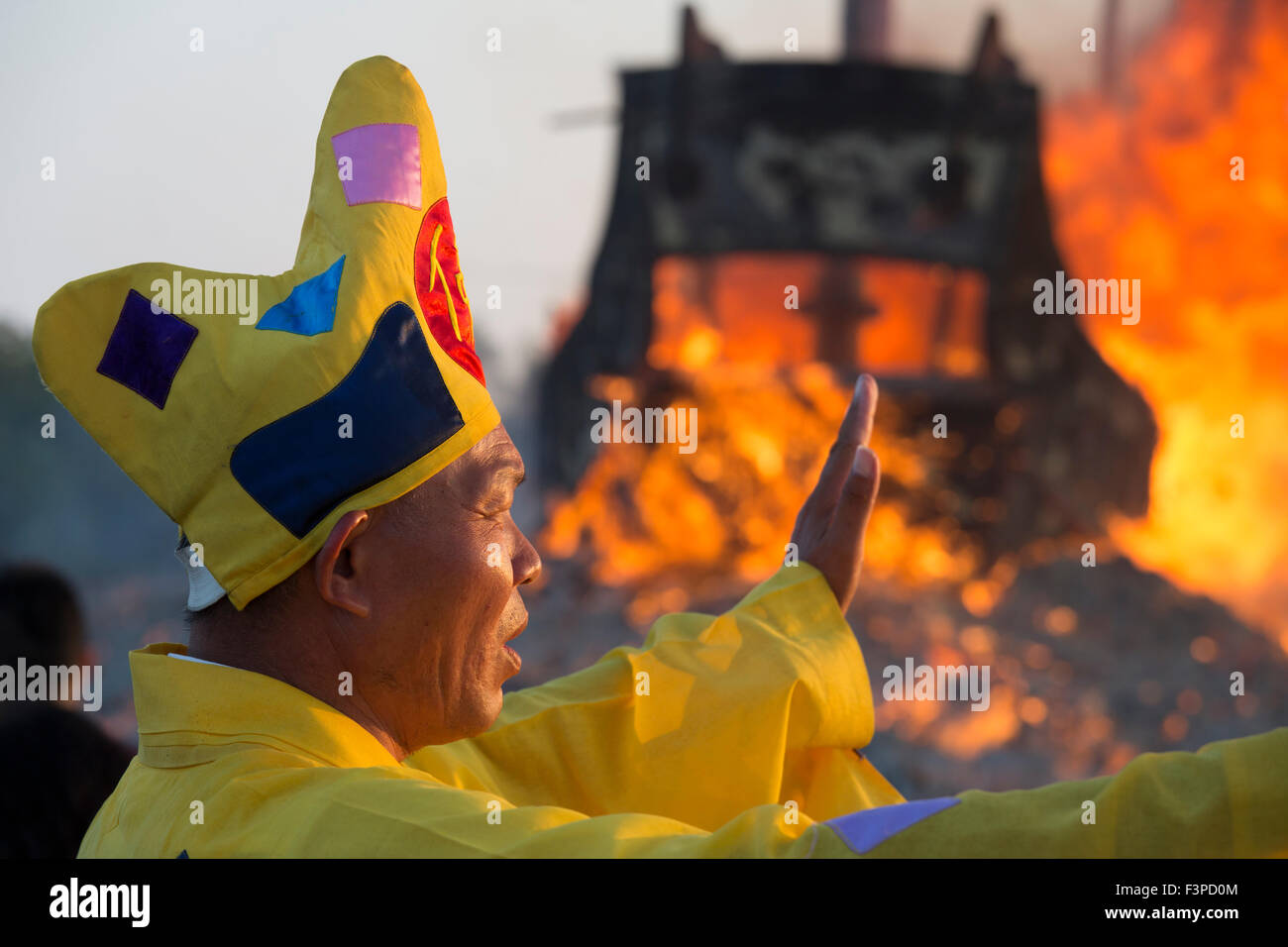 Un prêtre taoïste chants incantations et prières comme un traditionnel junk est brûlé à l'aube du 11 octobre, 2015 dans le cadre d'une cérémonie d'une semaine pour débarrasser le Sud du local de la communauté de pêche taiwanais de Shanghai de mauvais esprits, les maladies et les mauvaises influences au cours des trois années à venir. La gravure de tri-annuelle du bateau King est l'un des plus grands festivals religieux de Taiwan. Banque D'Images