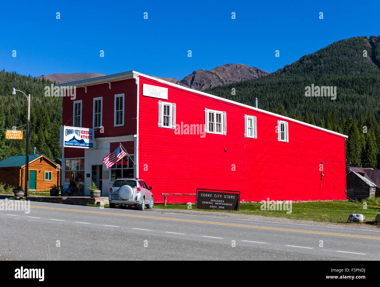 Vue extérieure d'un rouge vif enfoncé revêtement métallique sur Cooke City Magasin Général ; Cooke City, Montana, USA Banque D'Images