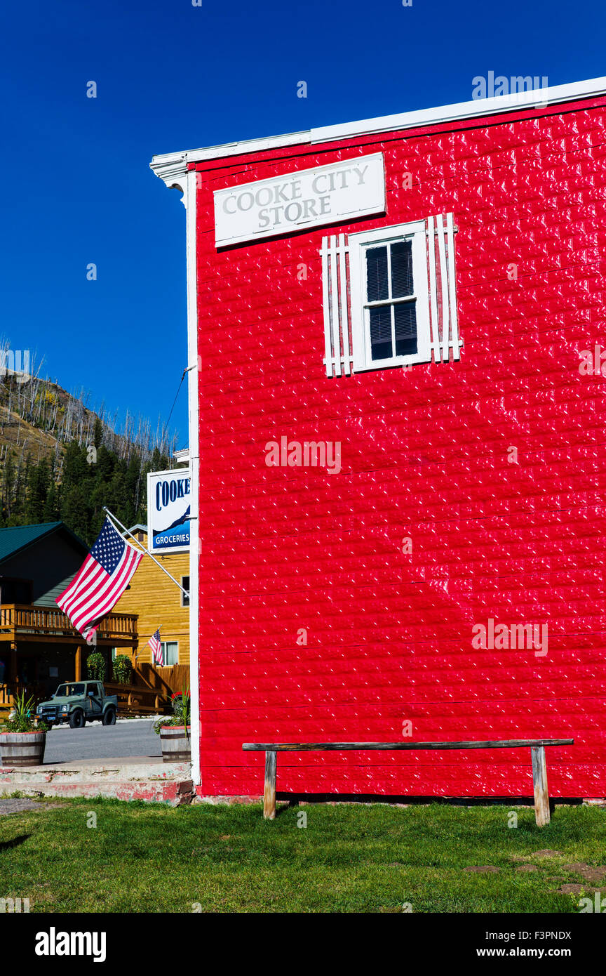 Vue extérieure d'un rouge vif enfoncé revêtement métallique sur Cooke City Magasin Général ; Cooke City, Montana, USA Banque D'Images