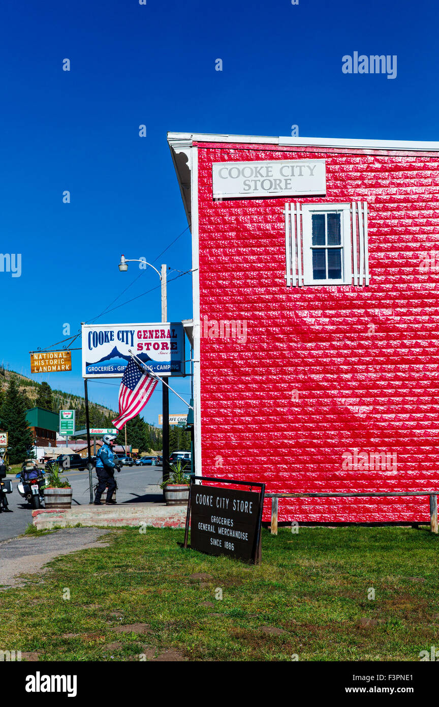 Vue extérieure d'un rouge vif enfoncé revêtement métallique sur Cooke City Magasin Général ; Cooke City, Montana, USA Banque D'Images