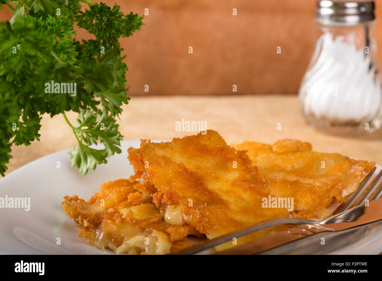 Le fromage frit sur plaque blanche avec fourchette et couteau Banque D'Images