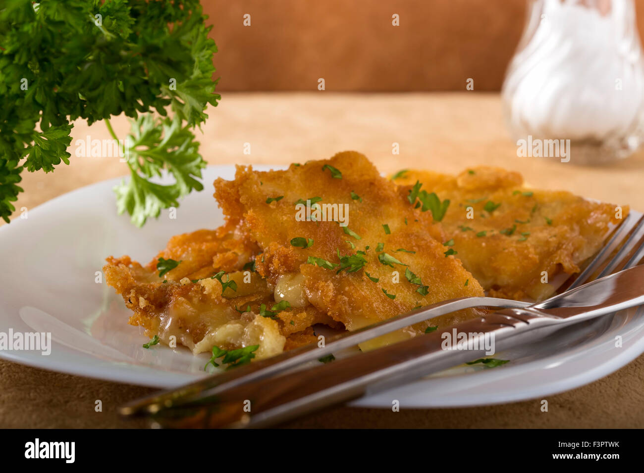 Le fromage frit sur plaque blanche avec fourchette et couteau Banque D'Images