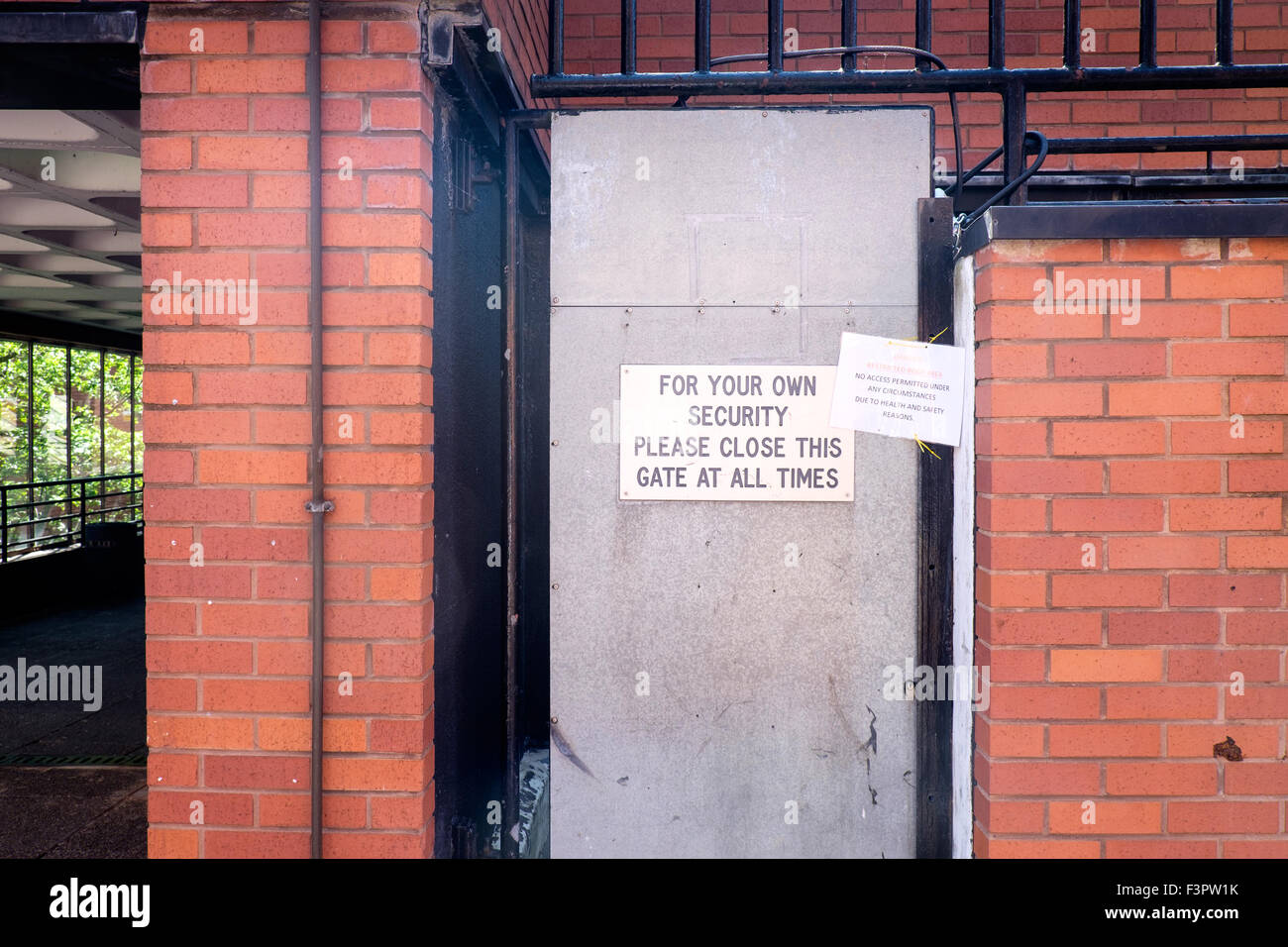 Panneau disant "pour votre propre sécurité, veuillez fermer cette porte en tout temps' dans le centre de la Cité, l'Université de Manchester, UK Banque D'Images