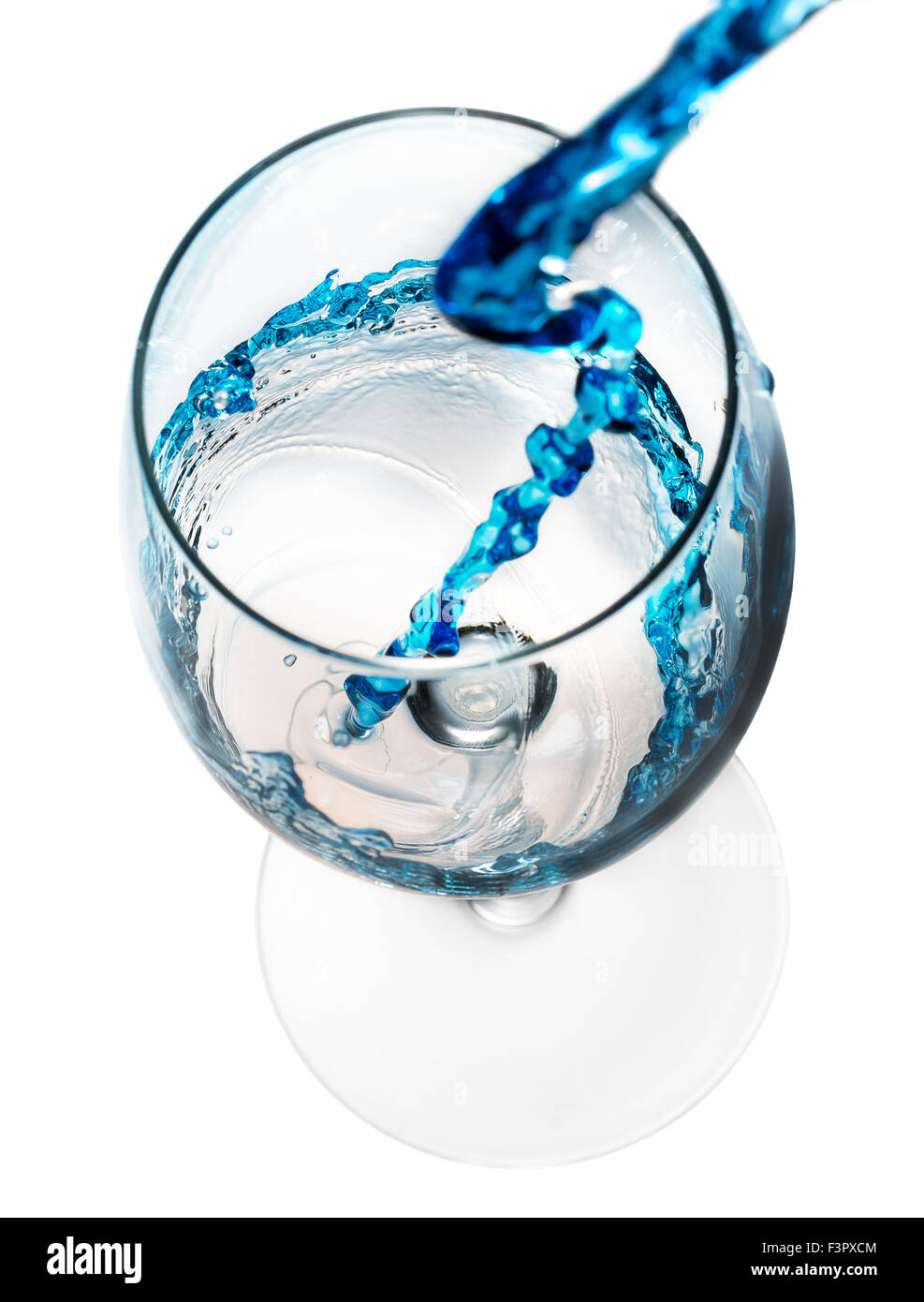 Boire de l'alcool bleu verser dans un verre isolé sur le fond blanc. Banque D'Images