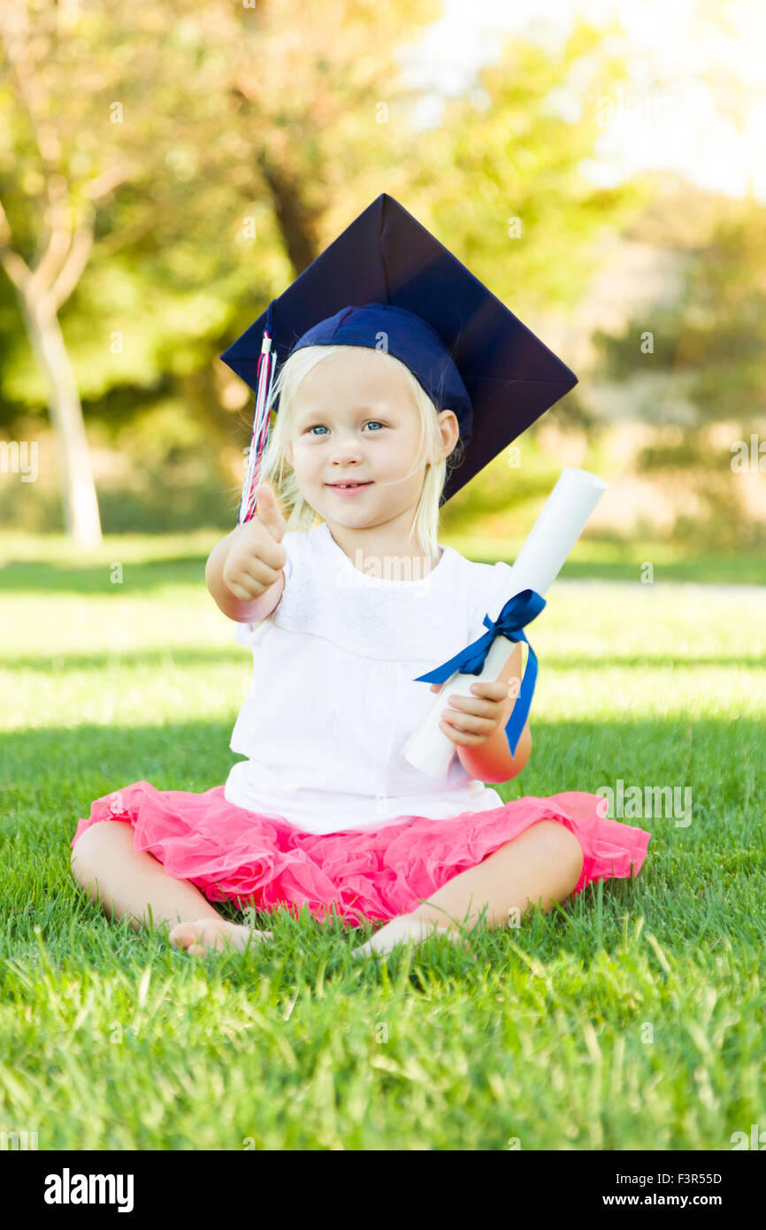 Cute Little Girl In Grass Wearing Graduation Cap Holding Diploma avec ...