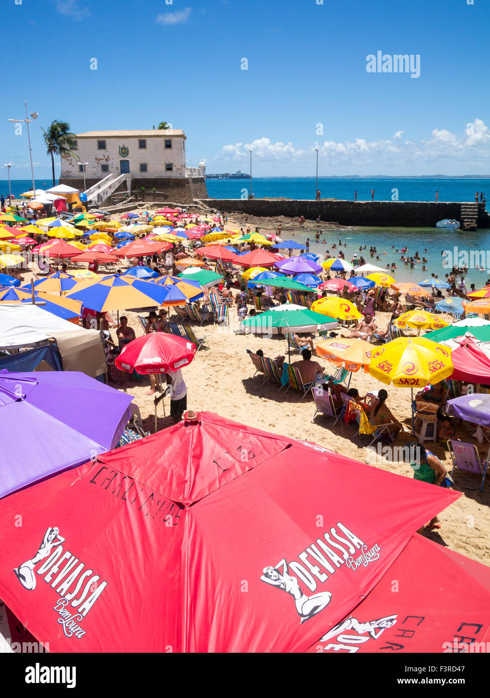 SALVADOR, BRÉSIL - 13 octobre 2013 : amateurs se rassemblent sous les parasols colorés sur un bel après-midi à Porto da Barra. Banque D'Images