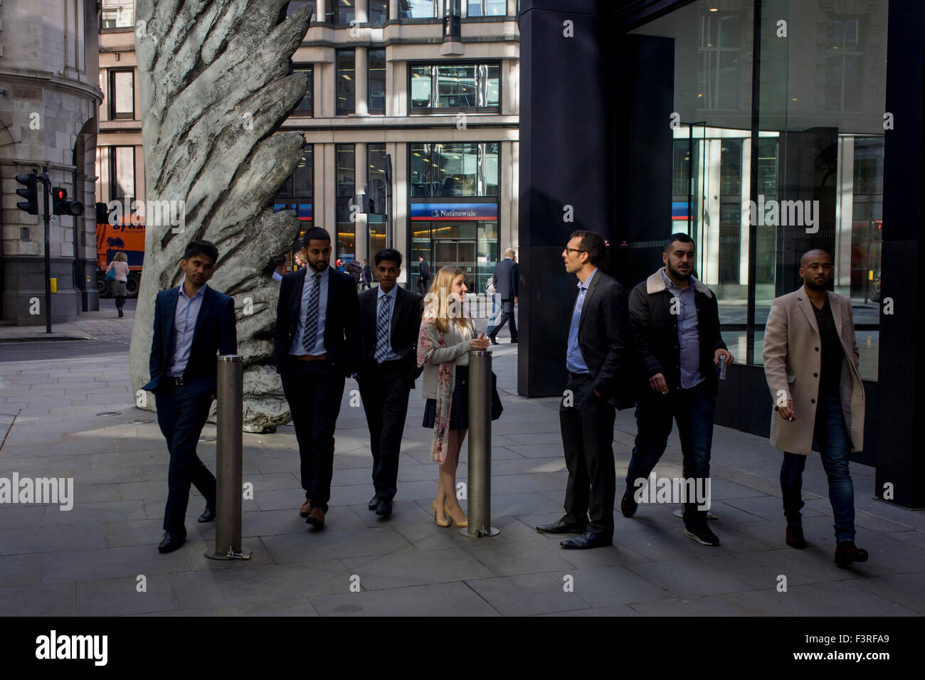 Les travailleurs de la ville par le passage de l'oeuvre d'un géant de l'aile de bronze à l'heure du déjeuner dans le quartier financier de Londres. Comme la lumière se reflète sur les immeubles de bureaux à proximité, la foule à l'heure du déjeuner devant ce géant des illustrations sur leur façon de réunions et sandwicheries. Les dix mètres de haut est la sculpture en bronze par le président de la Royal Academy of Arts, Christopher Le Brun, commandé par Hammerson en 2009. Elle est appelée 'La Ville' de l'aile et a été jeté par Morris Singer, fondateurs de l'art réputé pour être la plus ancienne fonderie d'art dans le monde. Banque D'Images