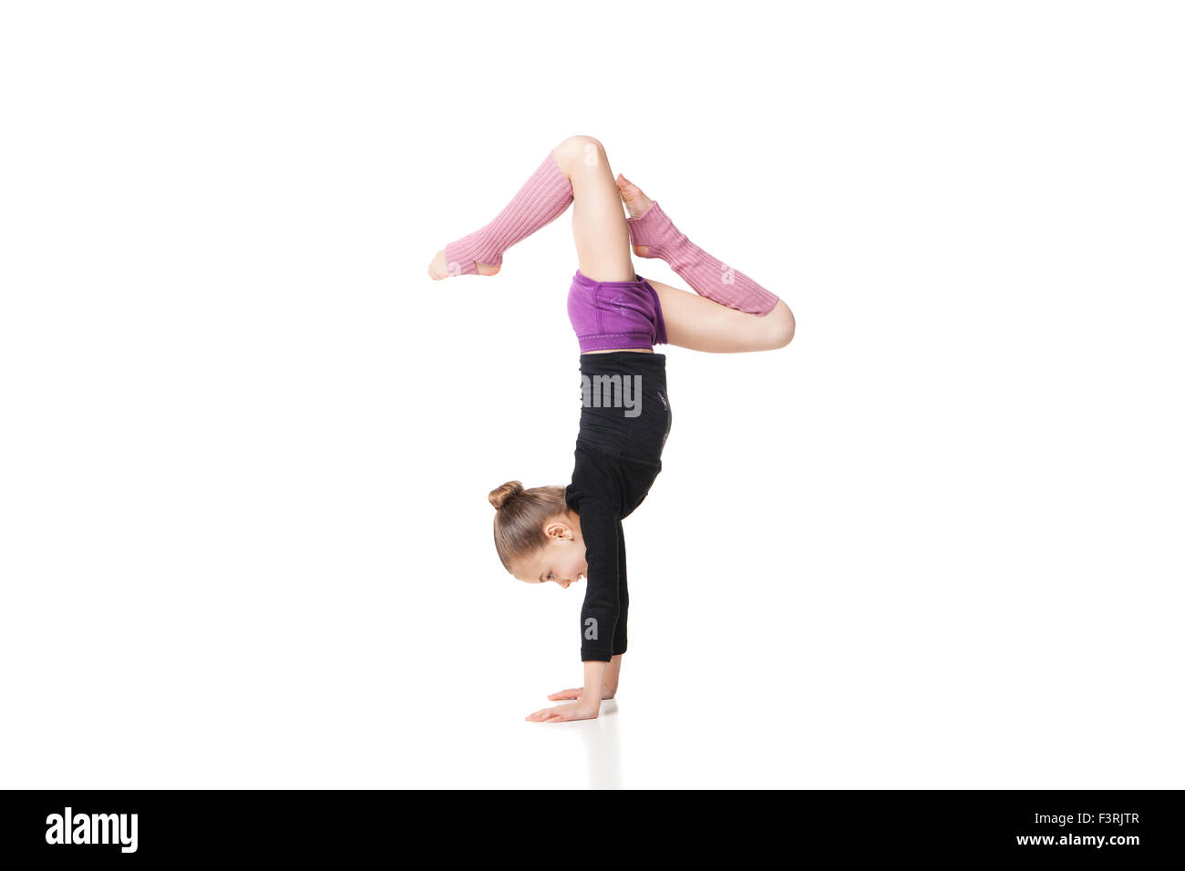 Pretty Little girl doing gymnastics over white background Banque D'Images