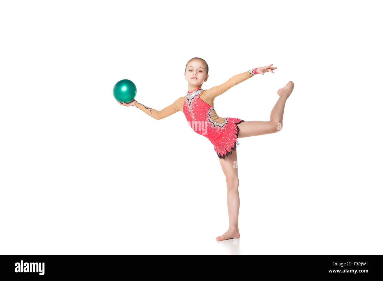 Jolie petite fille faire la gymnastique avec une boule sur fond blanc Banque D'Images