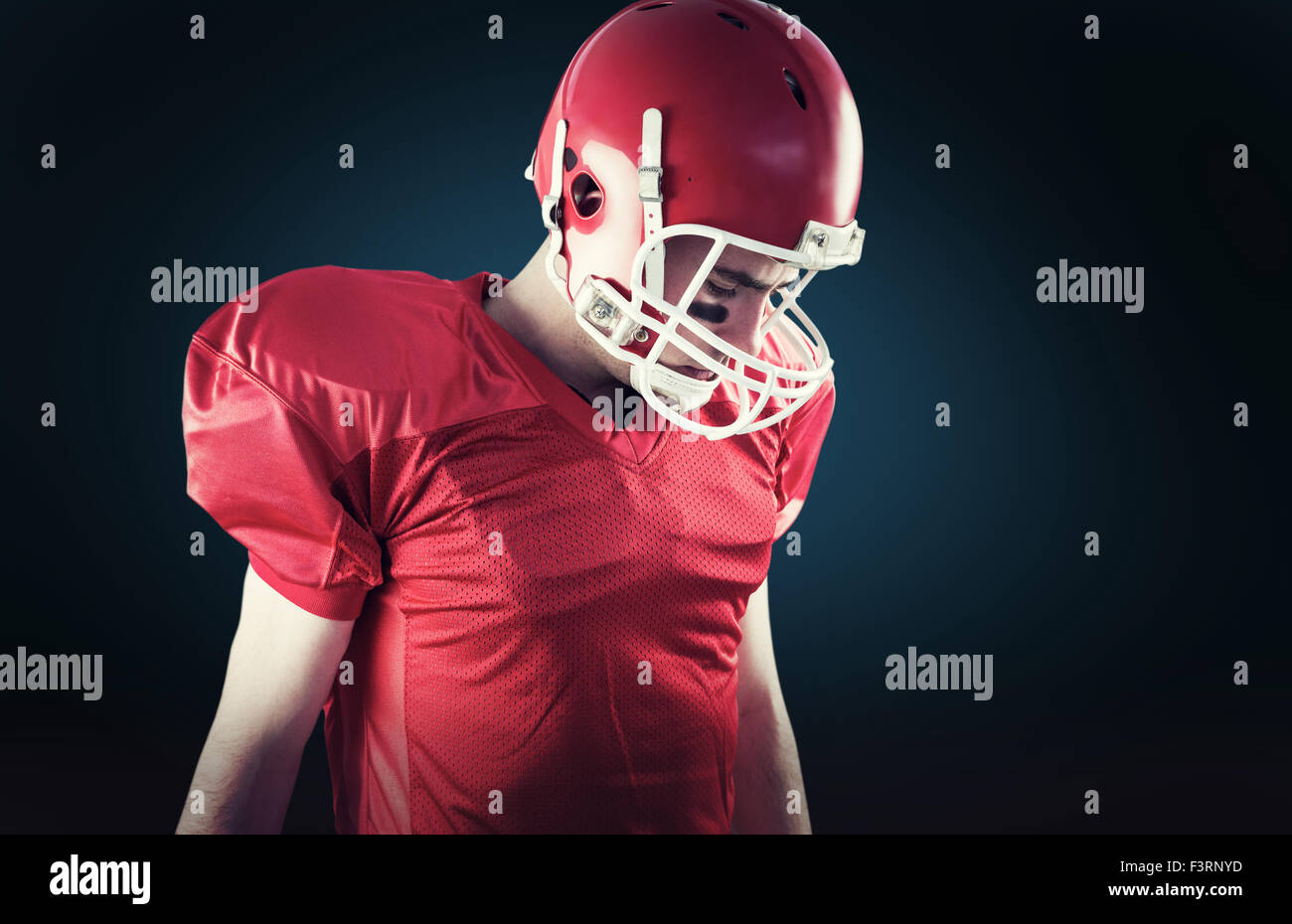 Image composite d'un joueur de football en tenant son casque sur la tête. Banque D'Images