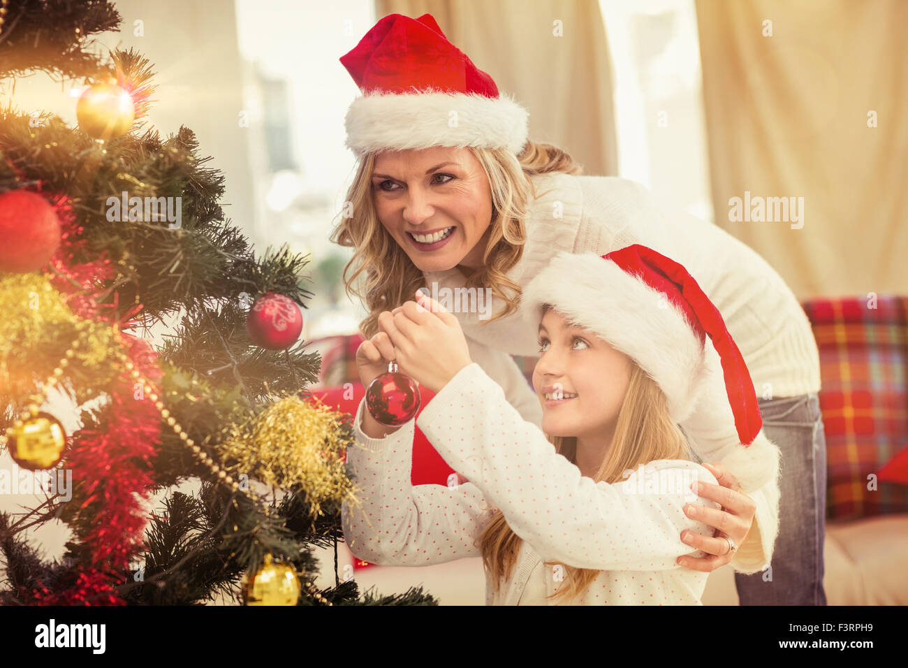 Mère et fille de fête decorating Christmas Tree Banque D'Images