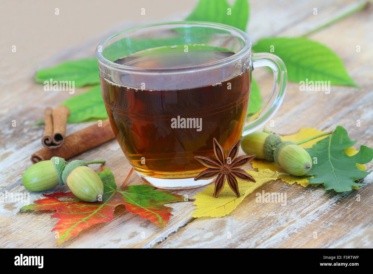 Thé noir en verre transparent, l'anis étoilé et les feuilles d'automne Banque D'Images