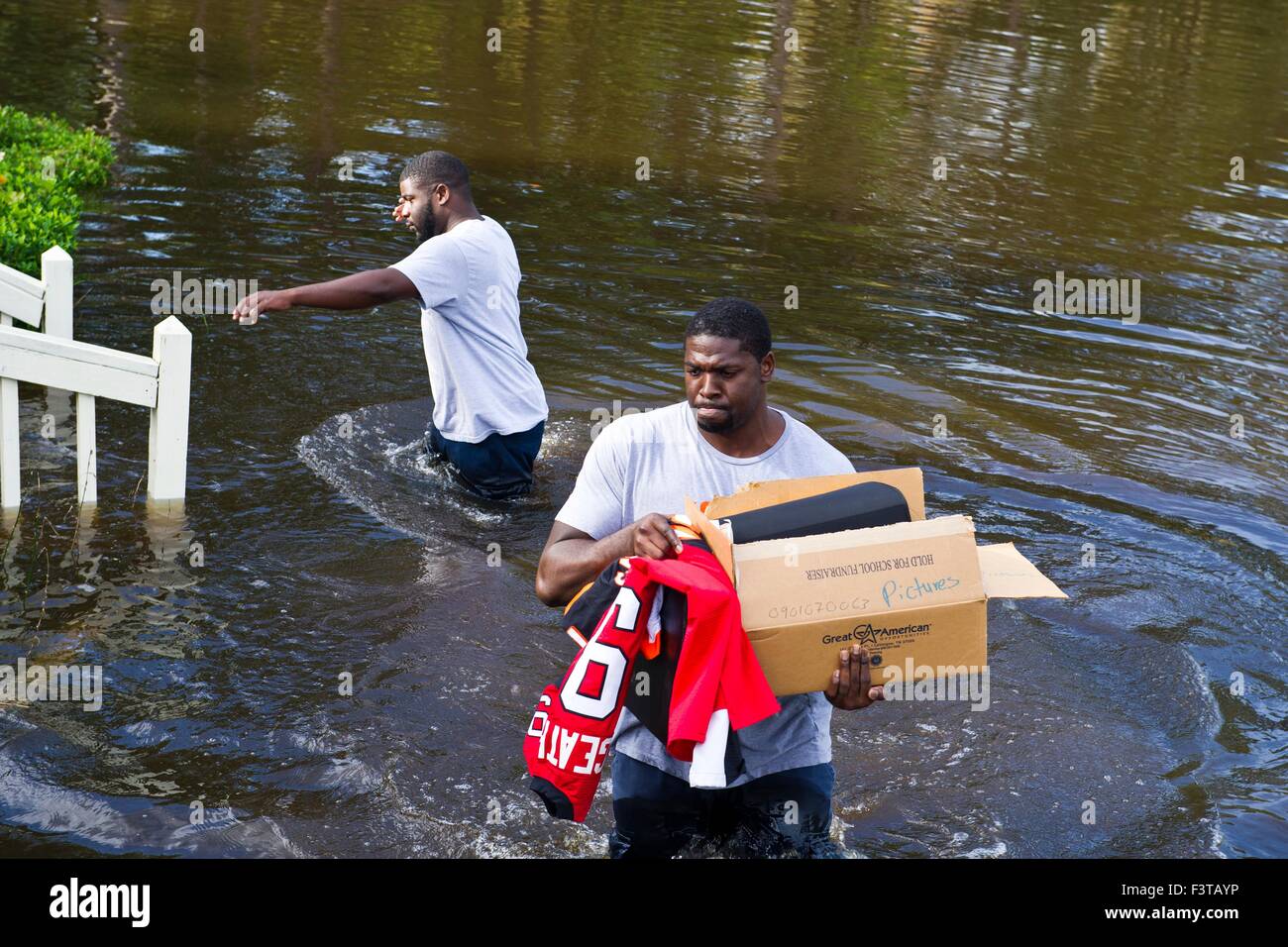 Pittsburgh Steelers football player Clifton Geathers aide à retirer les biens de sa maison familiale submergés par les inondations 10 octobre 2015 Browns Ferry, Caroline du Sud. De grandes parties de la Caroline du Sud a souffert de pluies record qui a inondé une grande partie de l'état. Banque D'Images