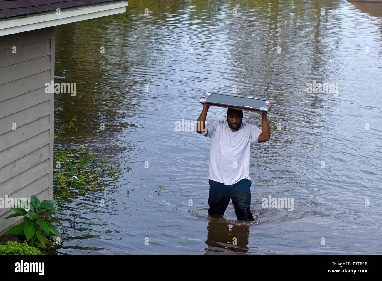 Pittsburgh Steelers football player Clifton Geathers aide à retirer les biens de sa maison familiale submergés par les inondations 10 octobre 2015 Browns Ferry, Caroline du Sud. De grandes parties de la Caroline du Sud a souffert de pluies record qui a inondé une grande partie de l'état. Banque D'Images