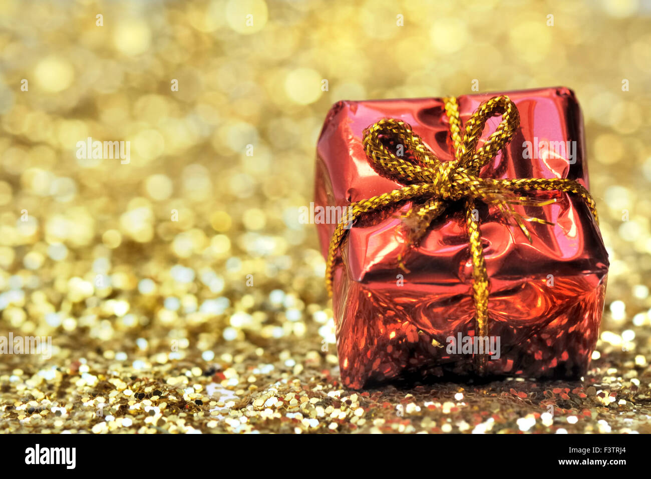 Petit cadeau de Noël sur golden glitter Banque D'Images