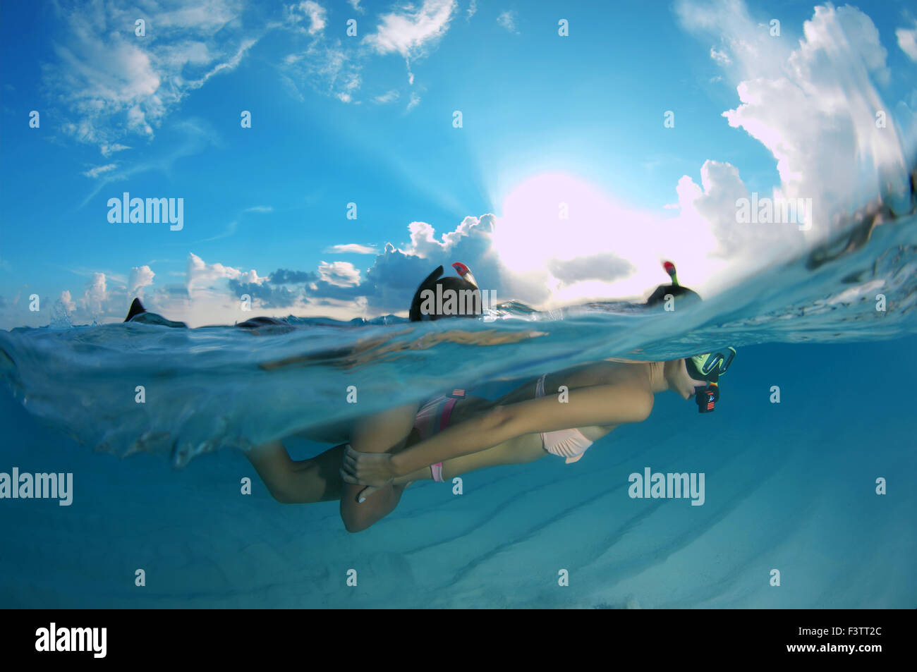 Duplex, jeune beau couple flottant au-dessus d'un fond de sable, de l'Océan Indien, les Maldives Banque D'Images