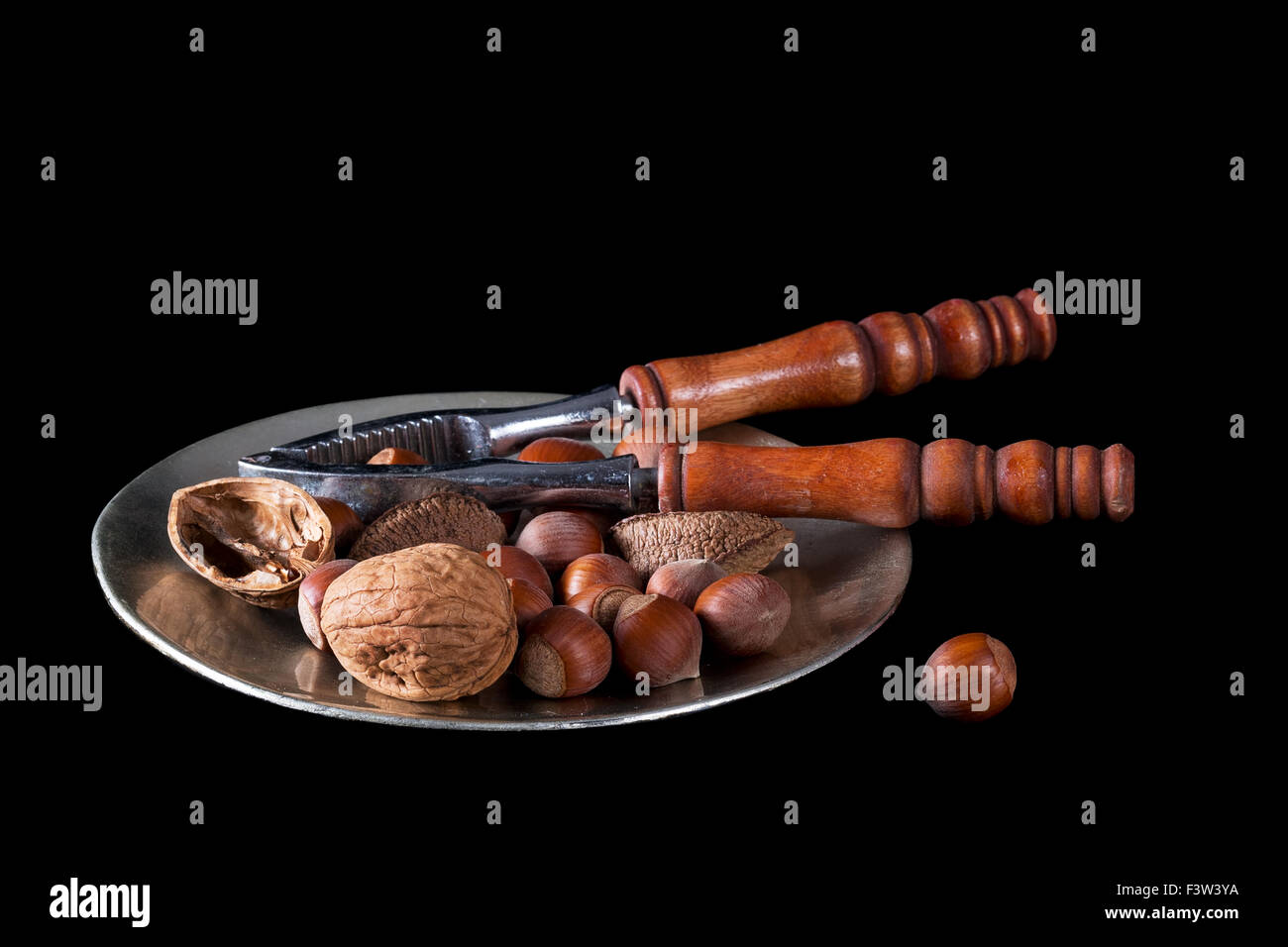 Un assortiment de noix et casse-noix sur noir Banque D'Images