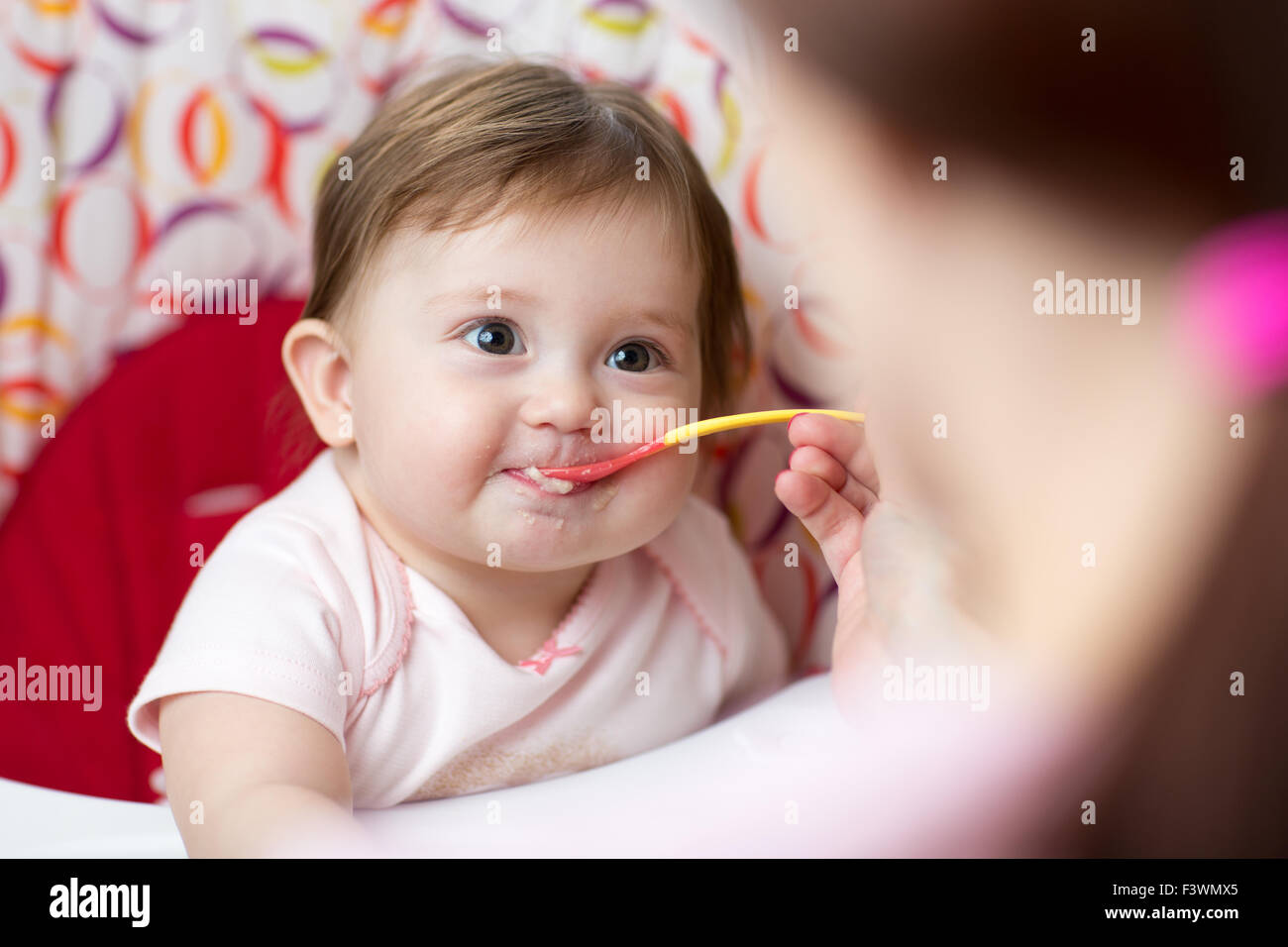 Mère nourrir bébé enfant fille Banque D'Images