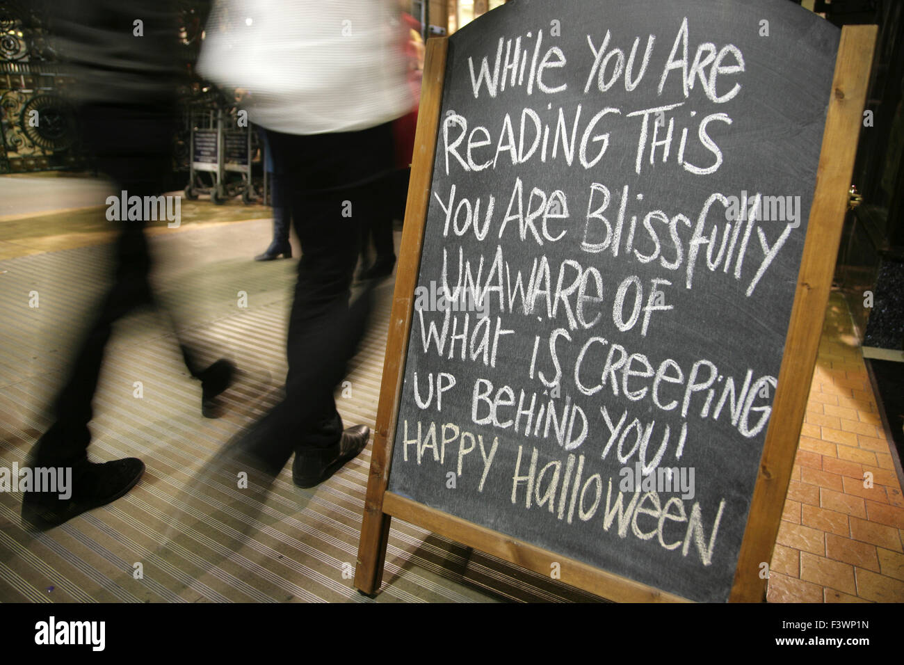 Les gens en passant devant le conseil d'avertissement d'Halloween. Banque D'Images