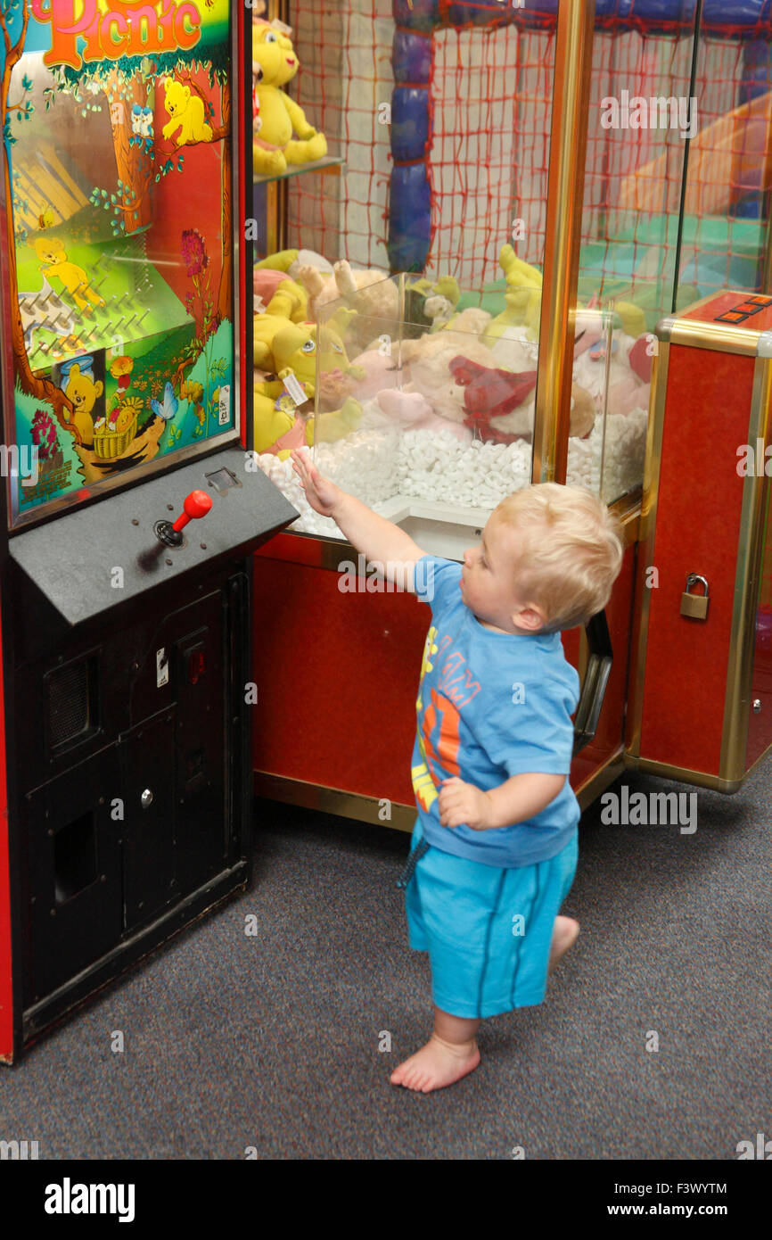 Tout-petit avec arcade machine en playbarn Banque D'Images
