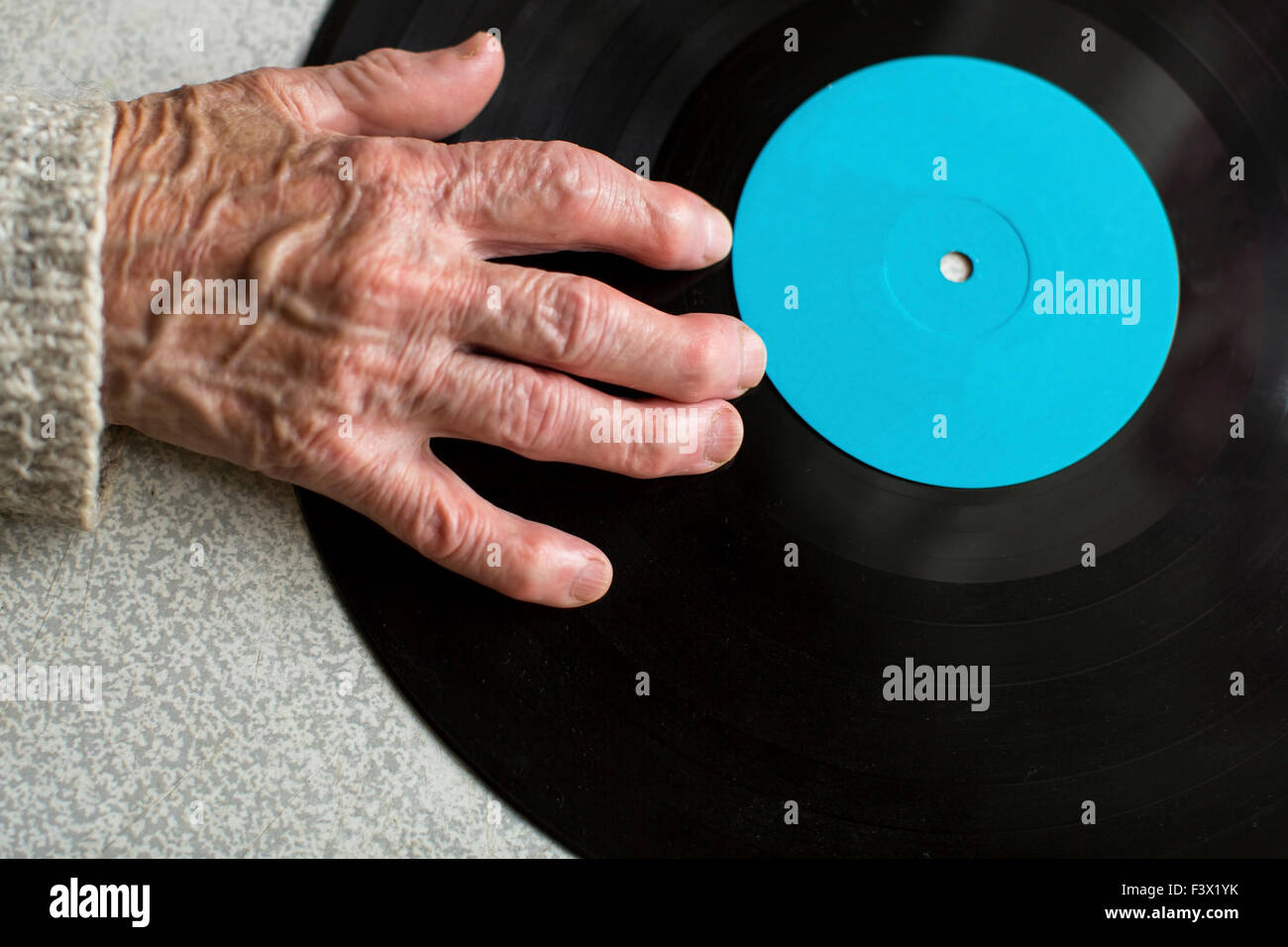 La main est sénile sur vinyle LP. Close-up du vieil homme ou vieille femme part. L'espace pour votre texte. Banque D'Images