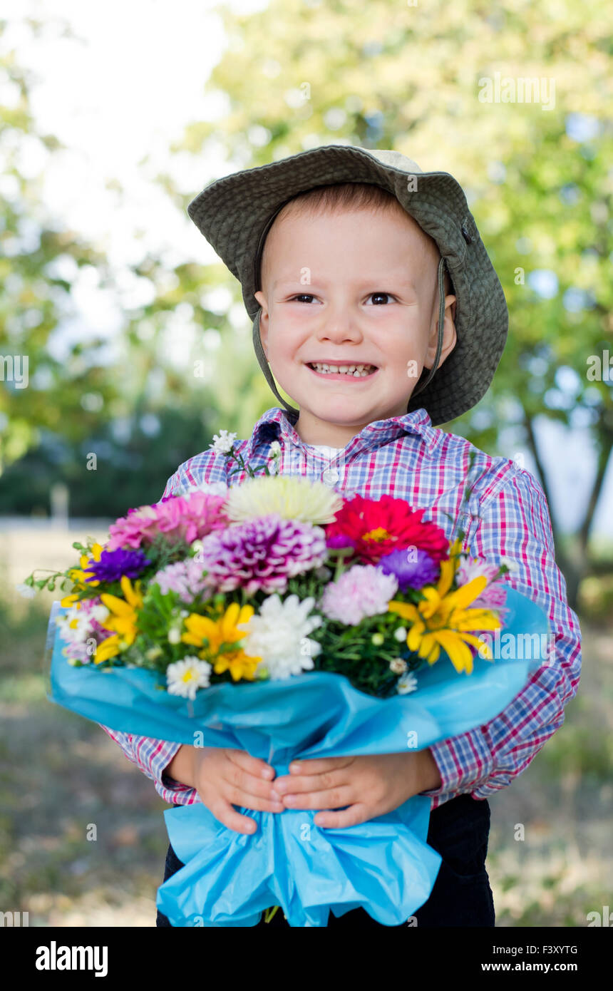 Jeune garçon souriant avec des fleurs Banque D'Images