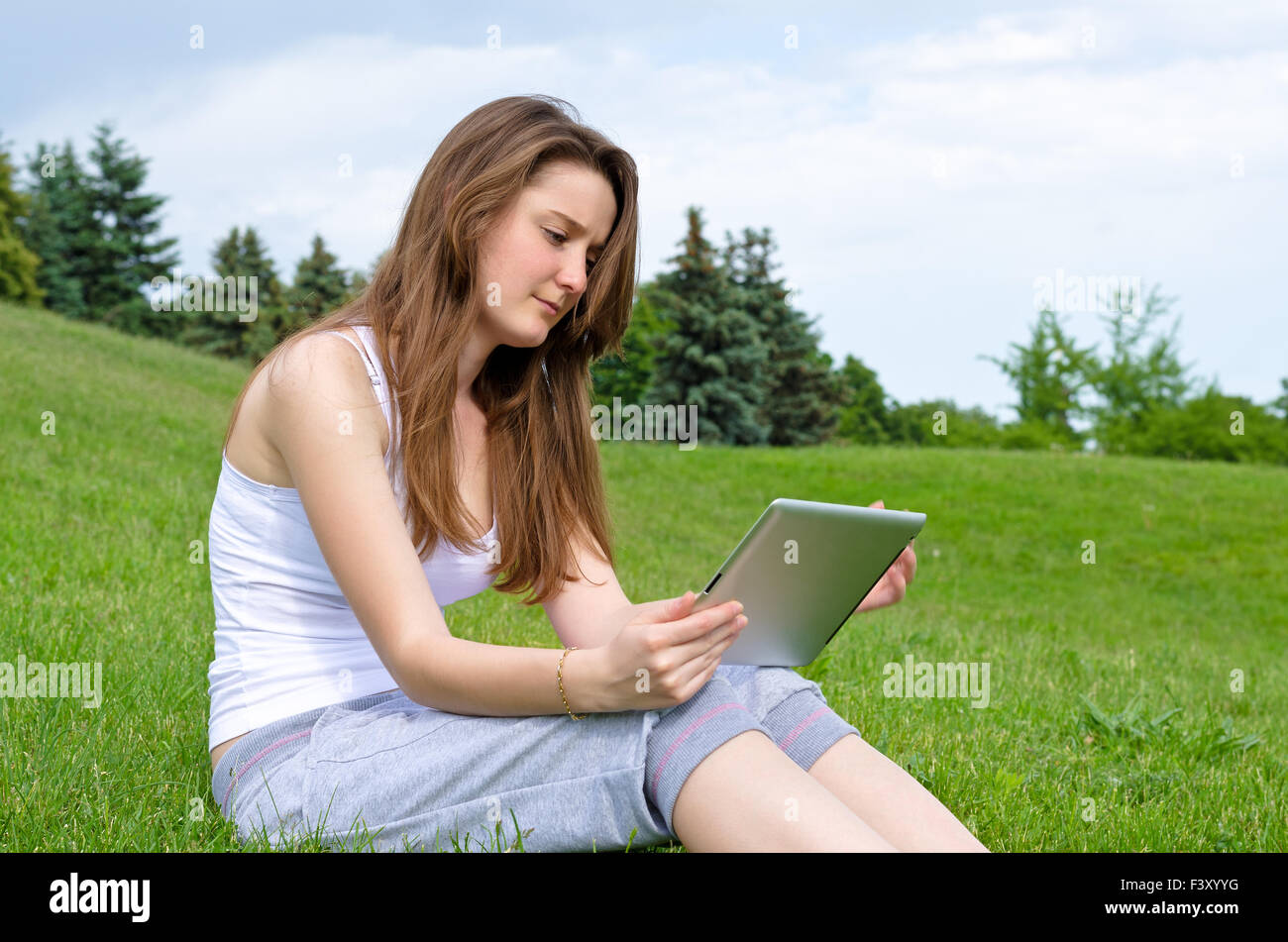 Femme lisant l'écran de son comprimé Banque D'Images