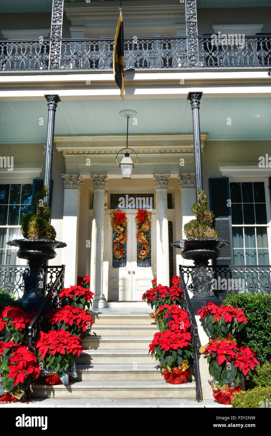 Ligne rouge poinsettias les escaliers comme des décorations de Noël à l'entrée & porche mansion dans le Garden District, New Orleans, LA Banque D'Images