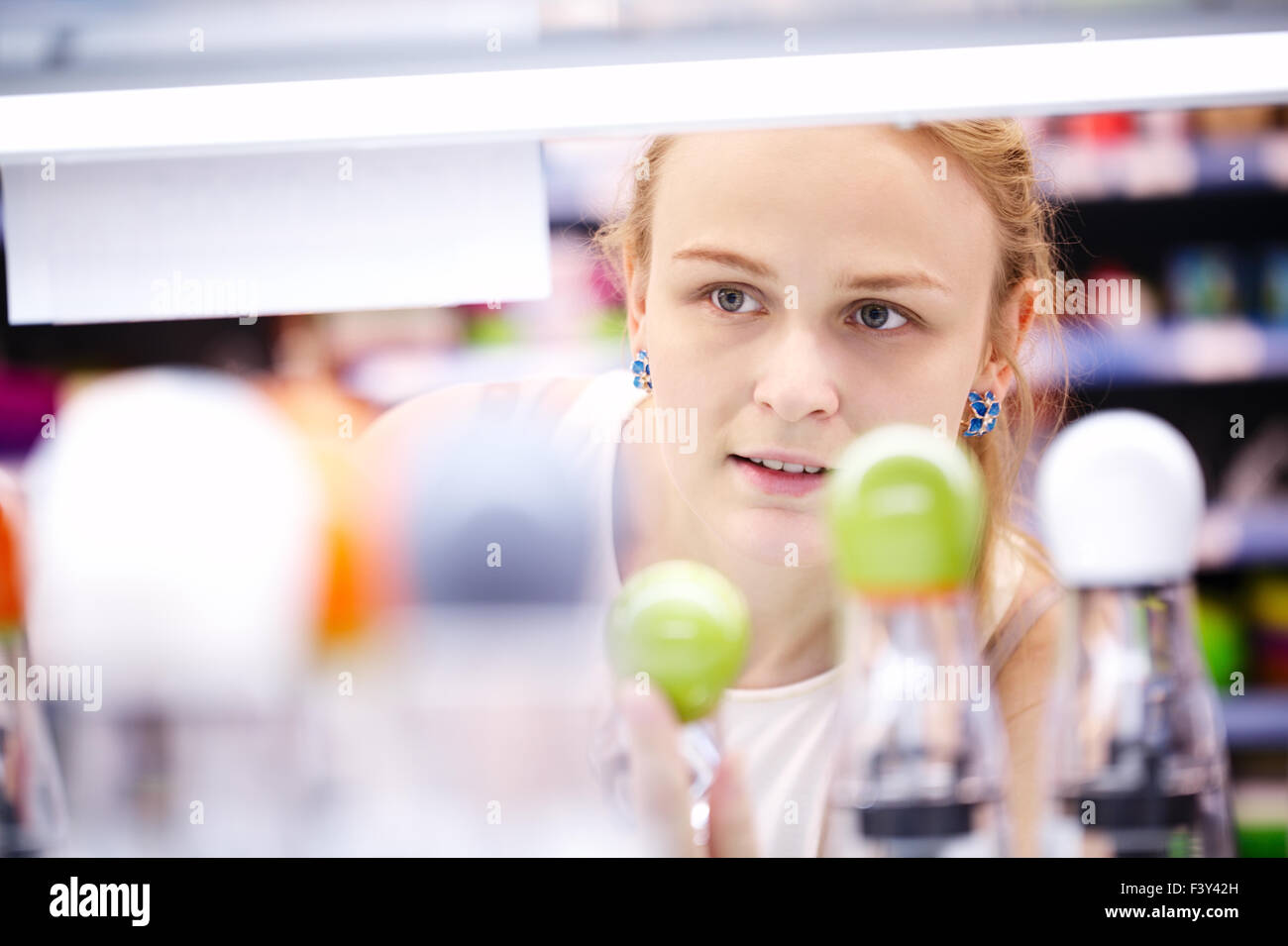 Jeune femme l'analyse des produits dans un magasin Banque D'Images