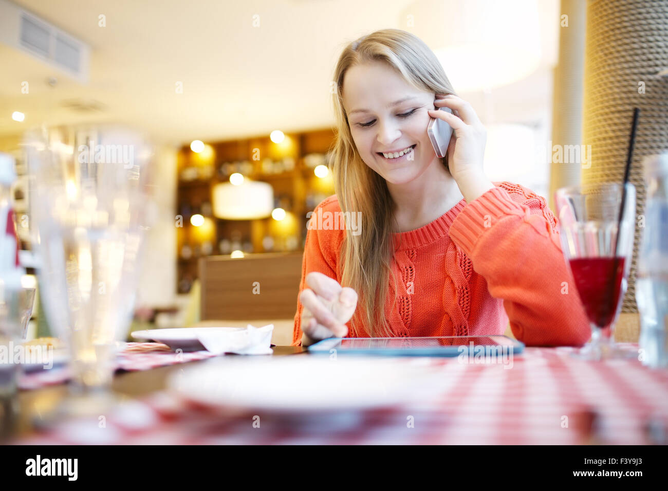 Woman in cafe avec surface tactile et téléphone Banque D'Images