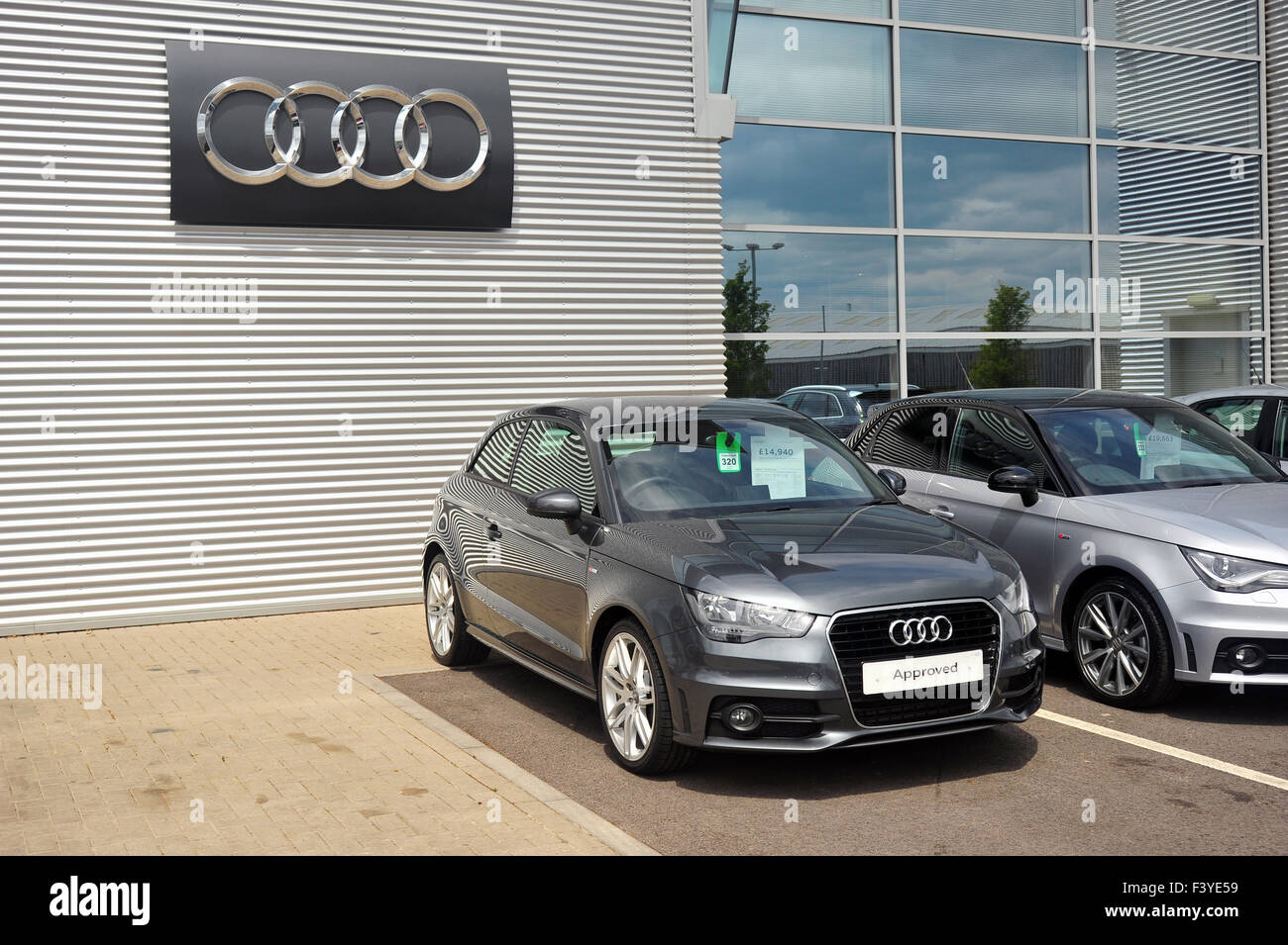 Une Audi A1 grise garée en face d'un grand logo Audi lors d'une concession Audi dans le Gloucestershire. Banque D'Images