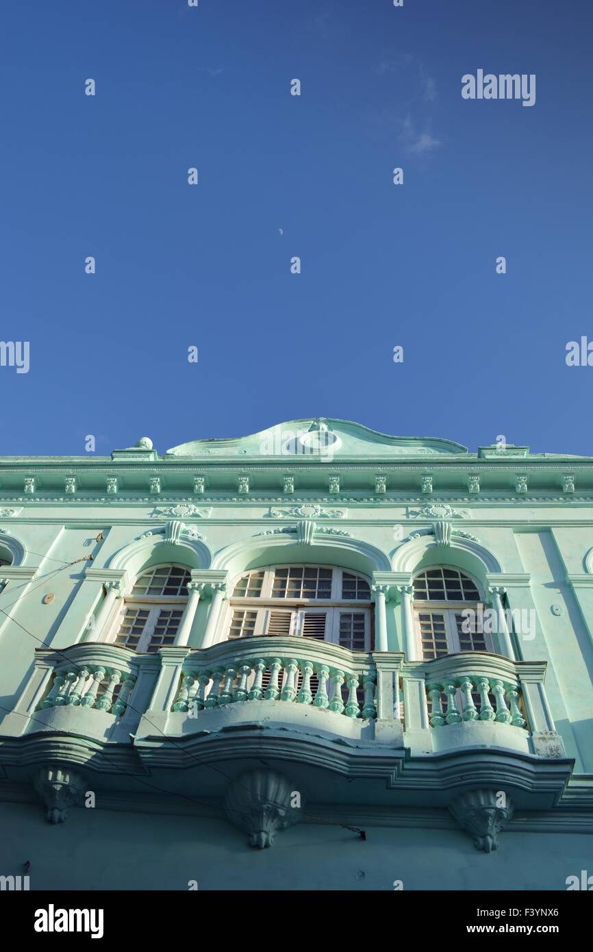Façade vert pastel du vieux bâtiment colonial, Santa Clara, Cuba avec un balcon balustrade sous les fenêtres et le ciel bleu au-dessus Banque D'Images