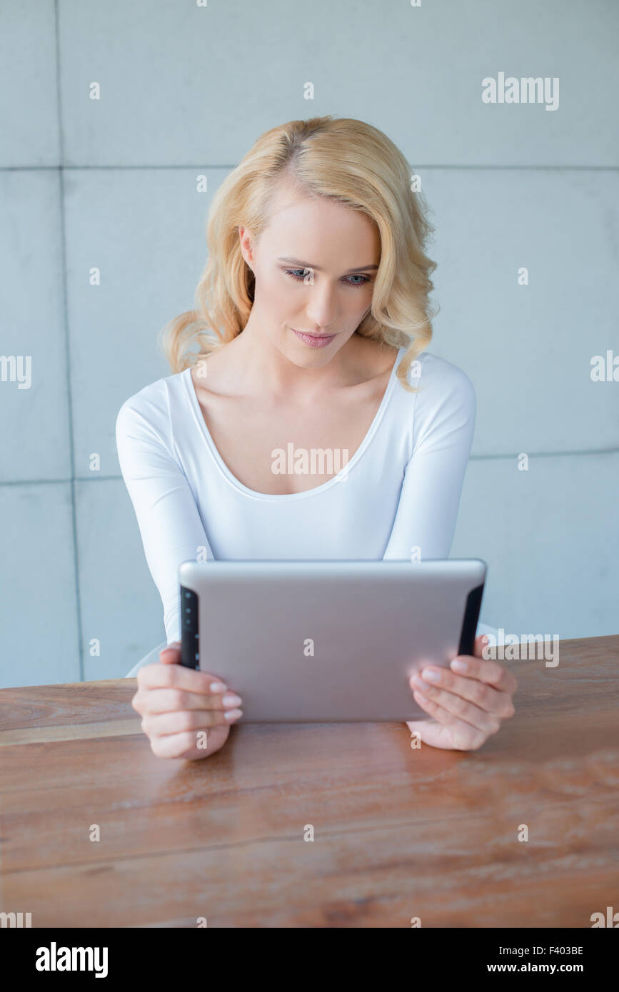 Belle Jeune femme lisant un tablet computer Banque D'Images