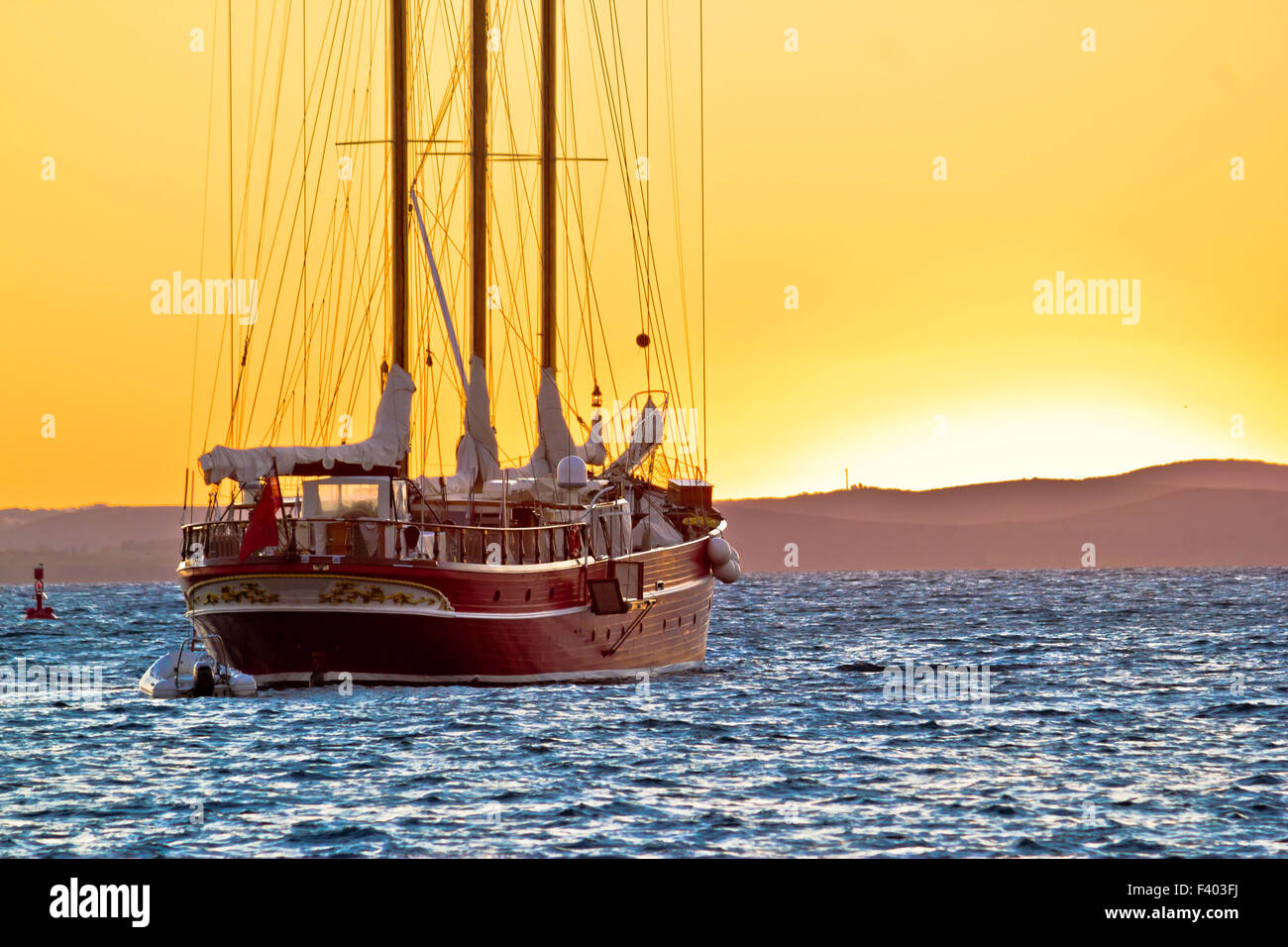 Voilier en bois au coucher du soleil d'or Banque D'Images