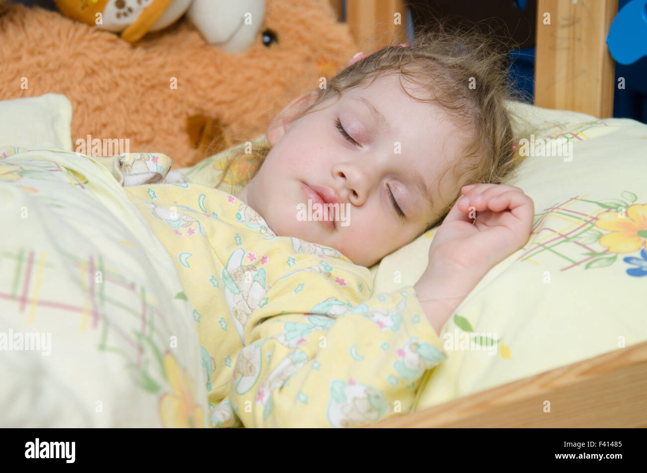 Trois ans, fille de dormir dans son berceau Banque D'Images