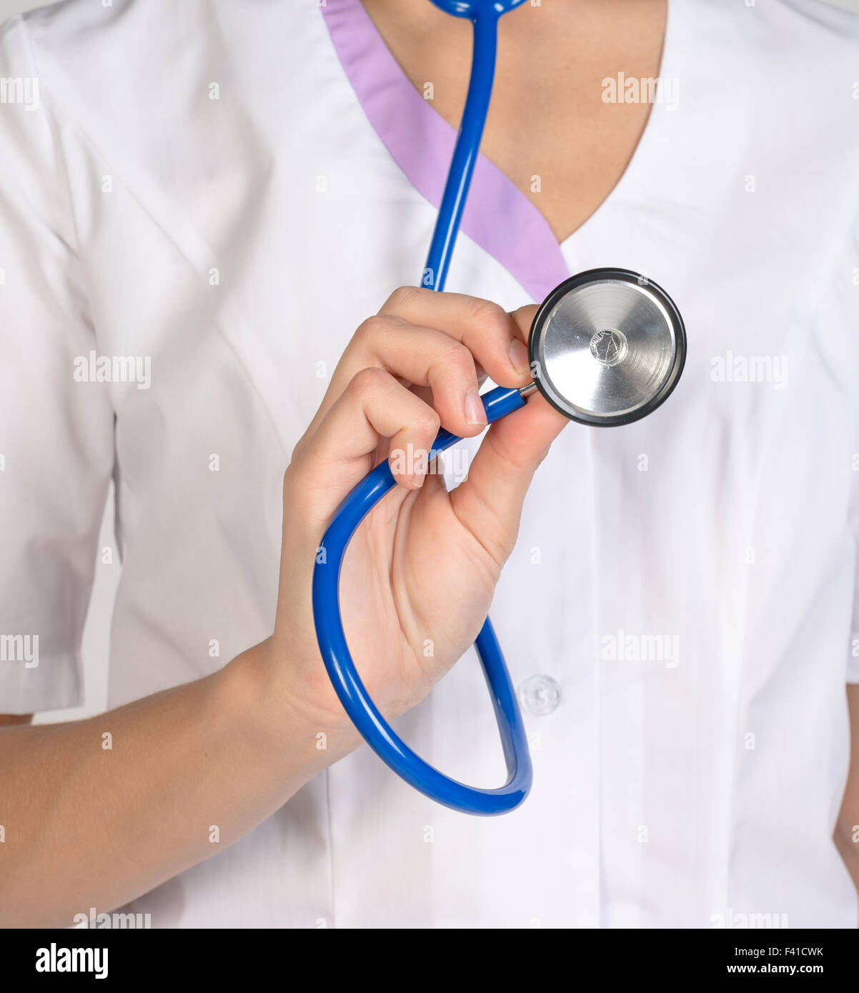 Femme médecin dans un lab coat holding a stethoscope Banque D'Images