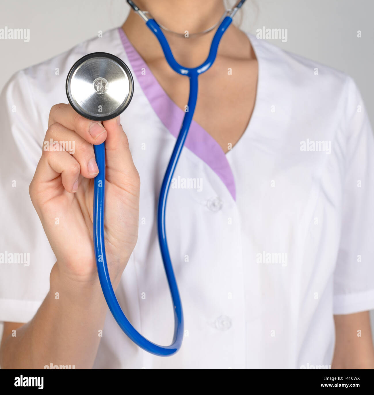 Femme médecin dans un lab coat holding a stethoscope Banque D'Images